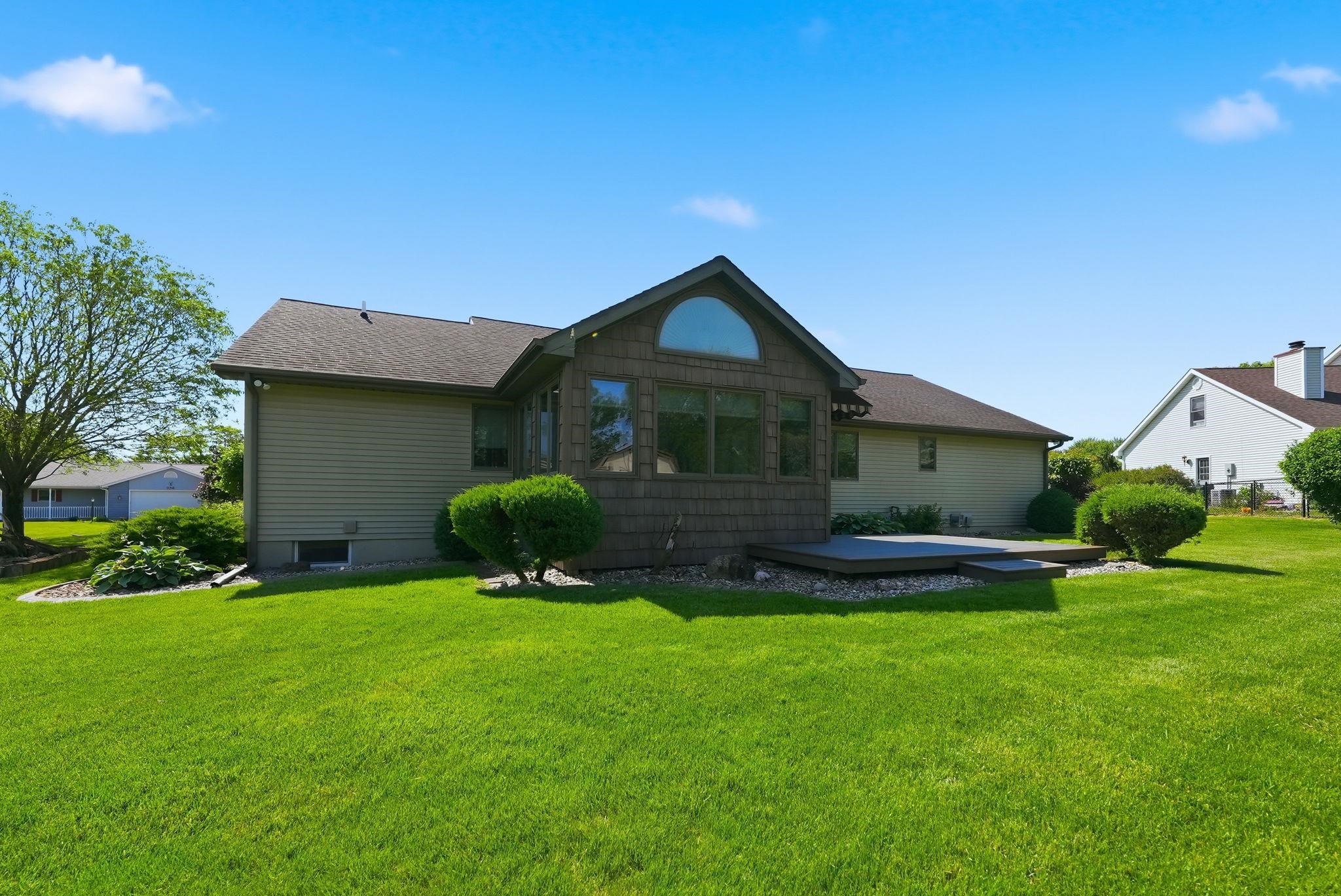Expansive green lawn with a multi-level composite deck, ideal for outdoor enjoyment