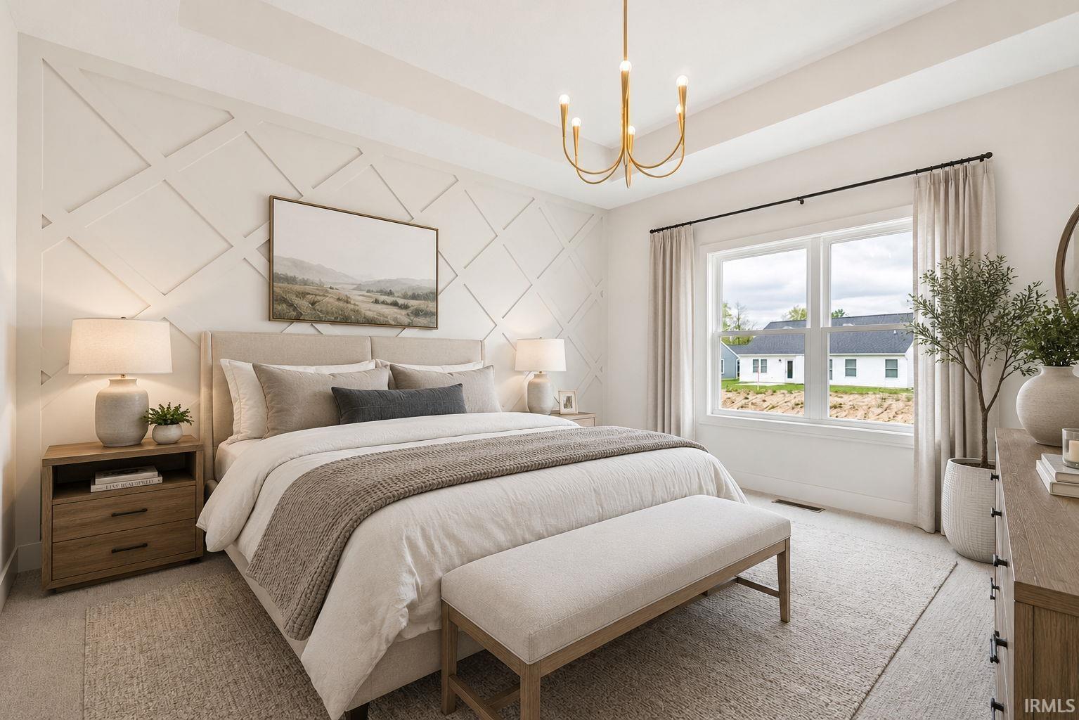 Bedroom featuring an accent wall with geometric molding, a large picture window, and a tray ceiling