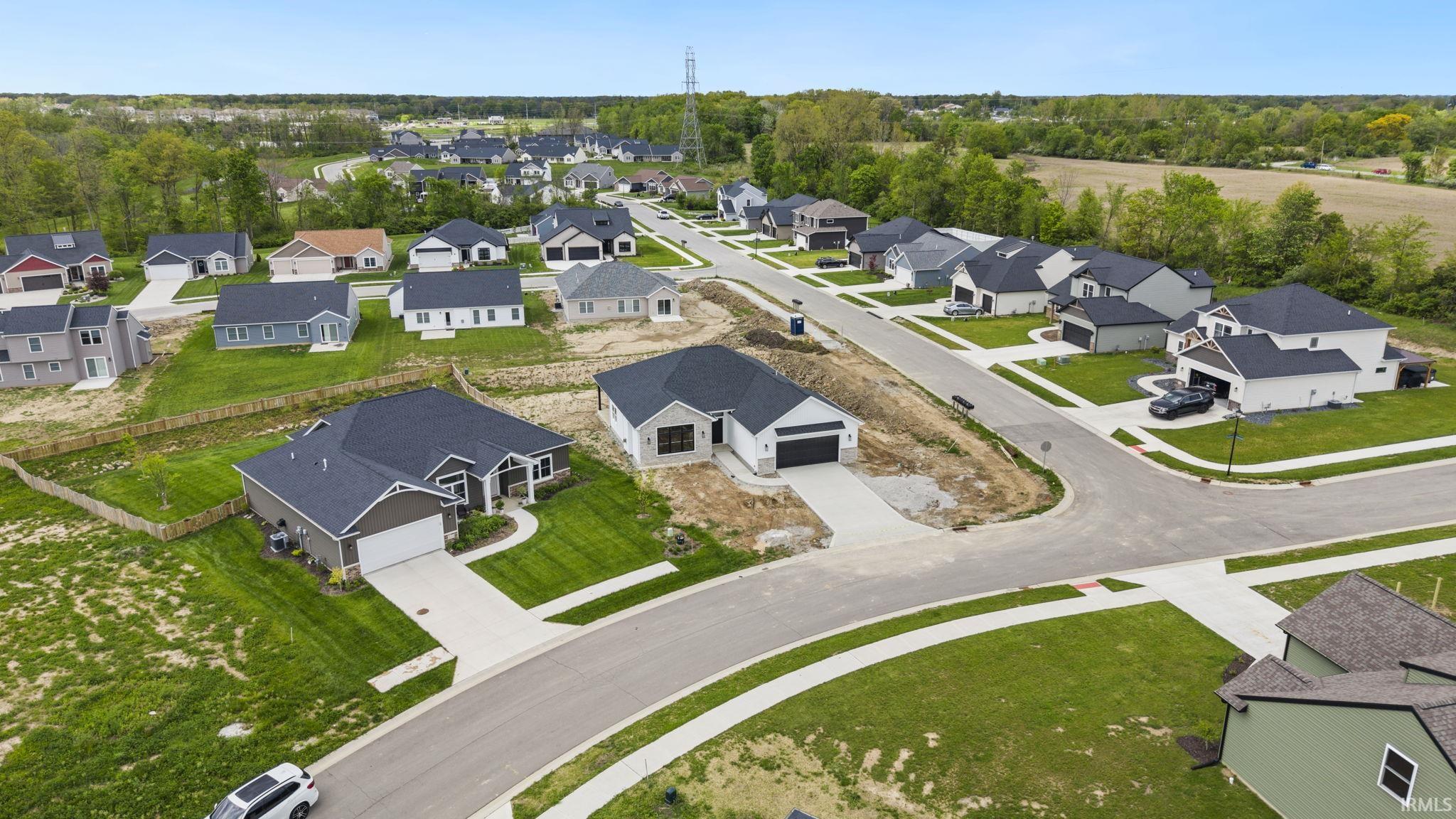 Recently constructed single-story residence featuring a dark shingle roof, light-colored siding, and a two-car garage