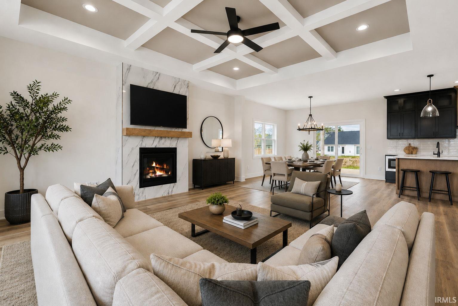 Spacious living area featuring a coffered ceiling, modern fireplace with a stone surround, and wood-finish flooring