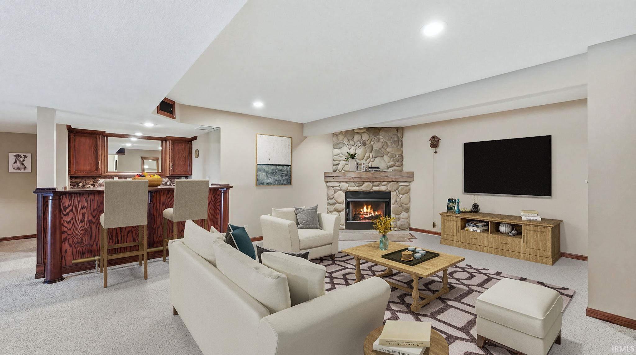 Spacious living area featuring a stone fireplace, recessed lighting, and soft carpeting