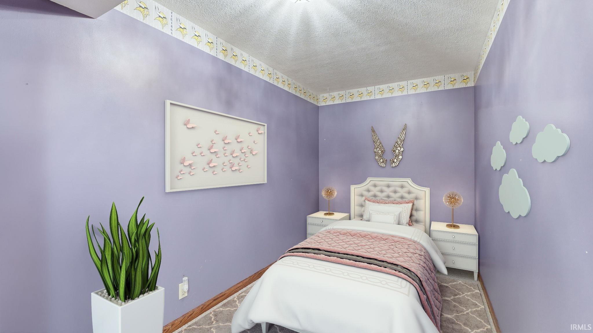 Room featuring lavender walls with decorative border, wood-finish flooring, and a textured ceiling