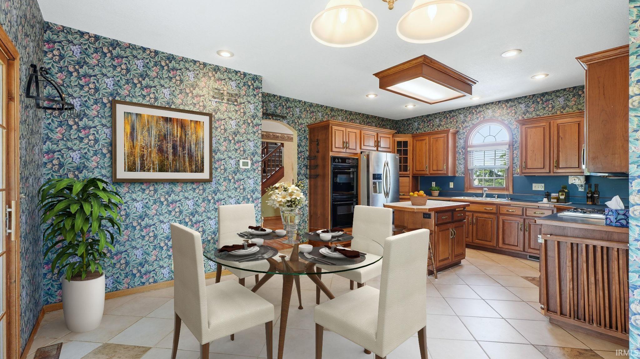 Kitchen featuring warm wood cabinetry, stainless steel appliances, a center island with countertop seating, and a large arched window