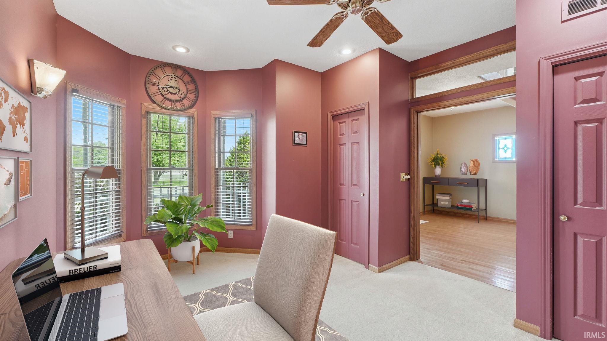 Bright room featuring a bay window with three vertical windows, recessed lighting, and a ceiling fan