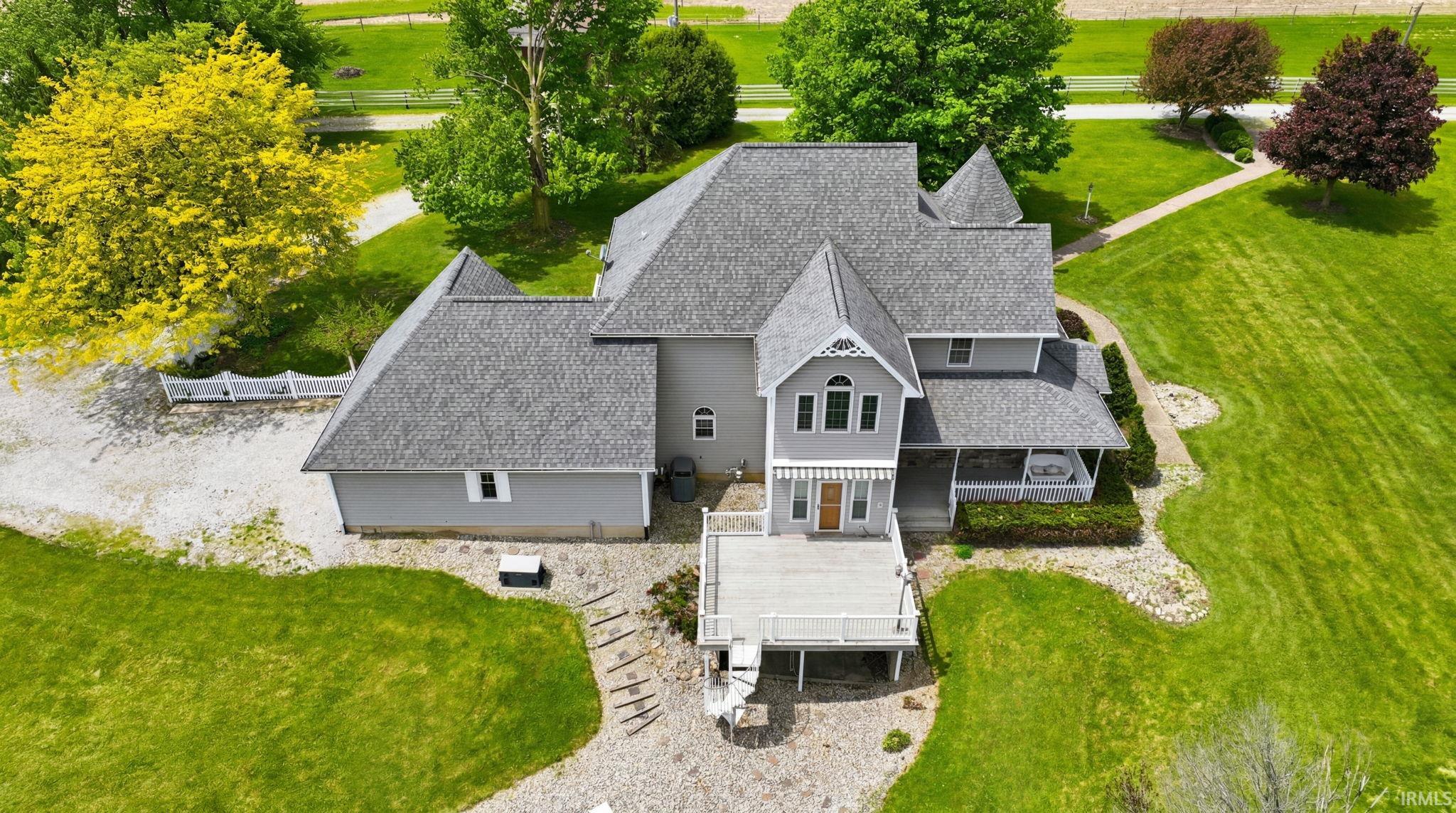 Expansive property featuring a multi-level deck, a covered porch with white railing, and a turret-style architectural element