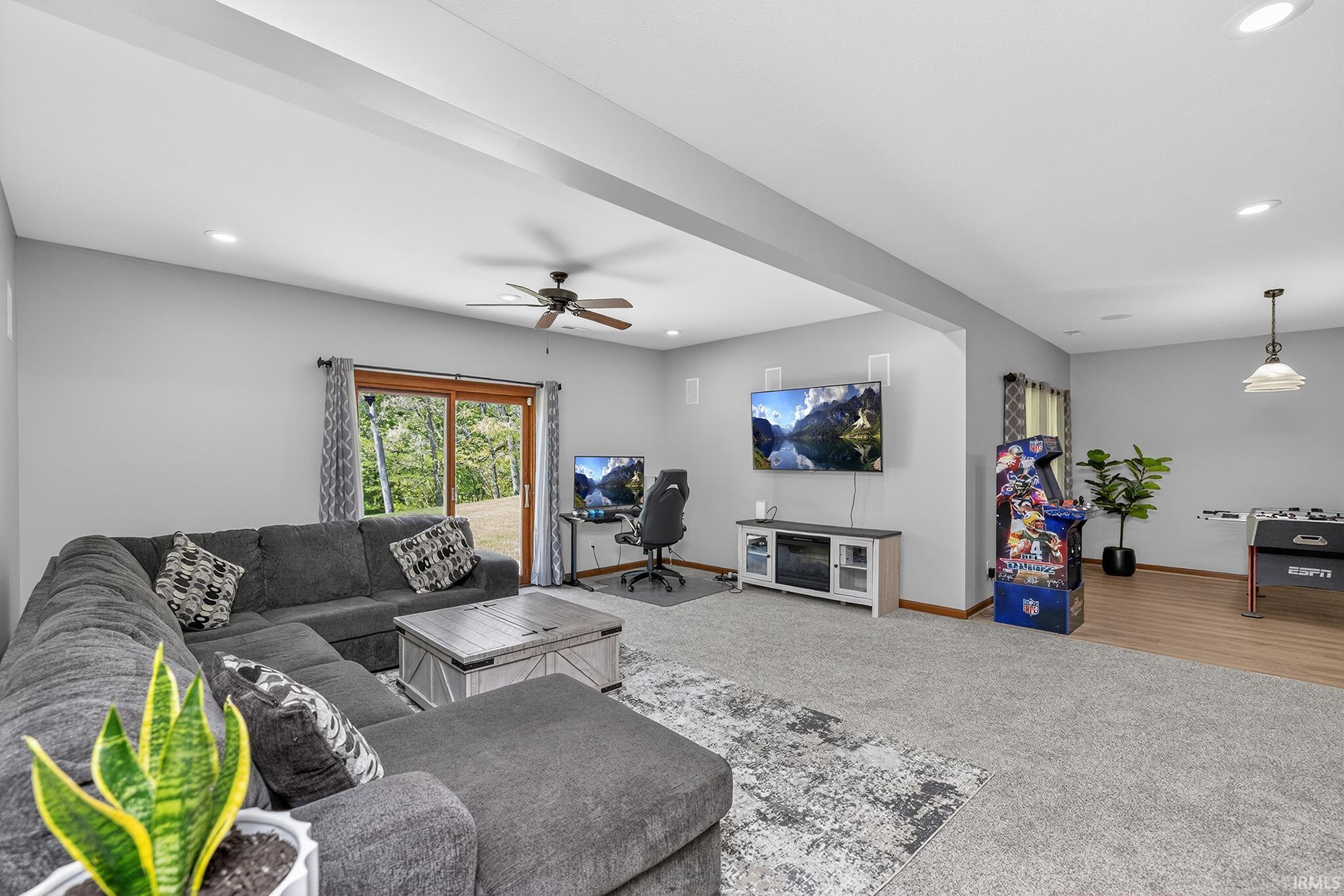 Spacious recreation room featuring recessed lighting, a ceiling fan, and a sliding glass door providing outdoor access