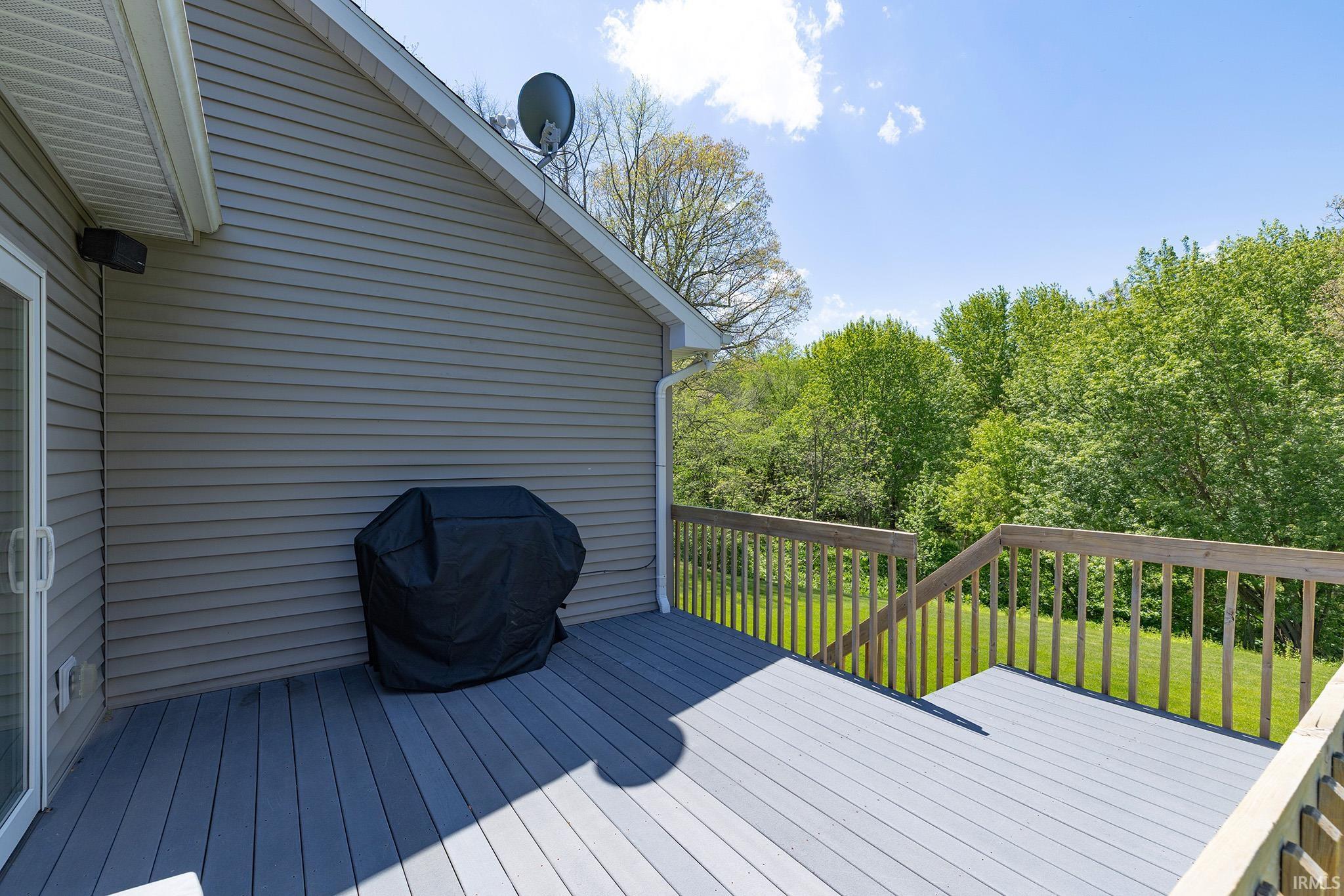 Spacious outdoor deck with gray composite decking and natural wood railings