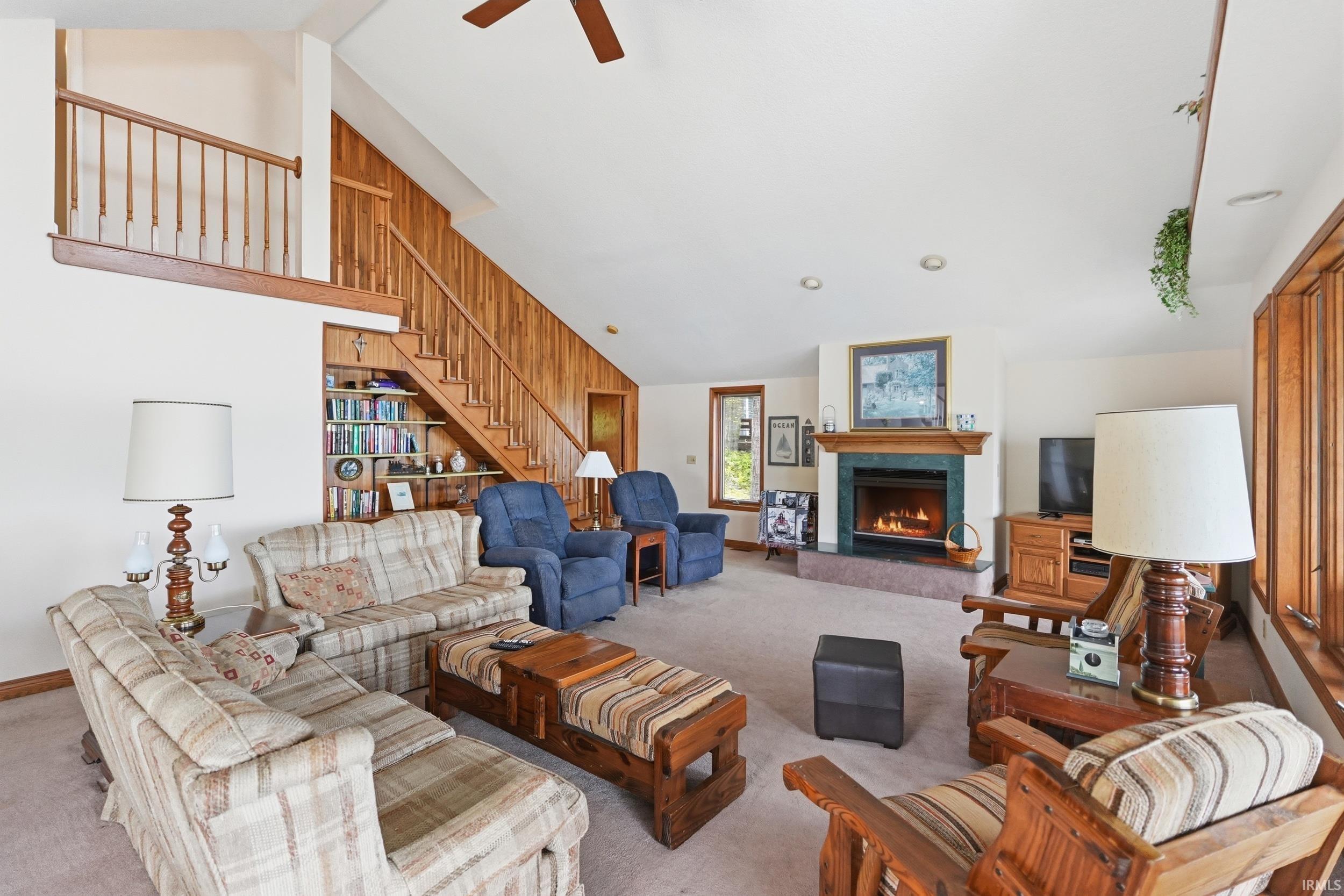 Spacious living area featuring a prominent fireplace with a stone hearth and mantel