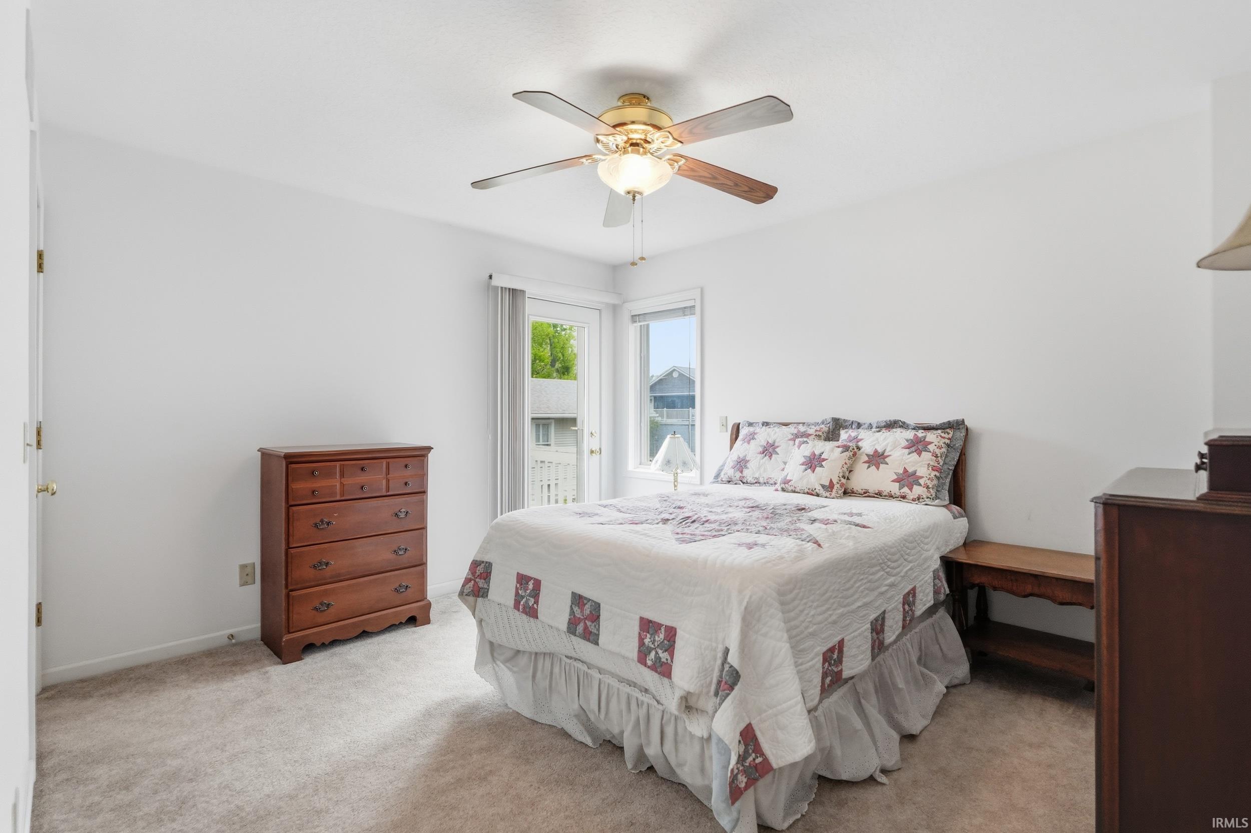 Neutral wall finishes, textured carpet flooring, and a ceiling fan with integrated lighting