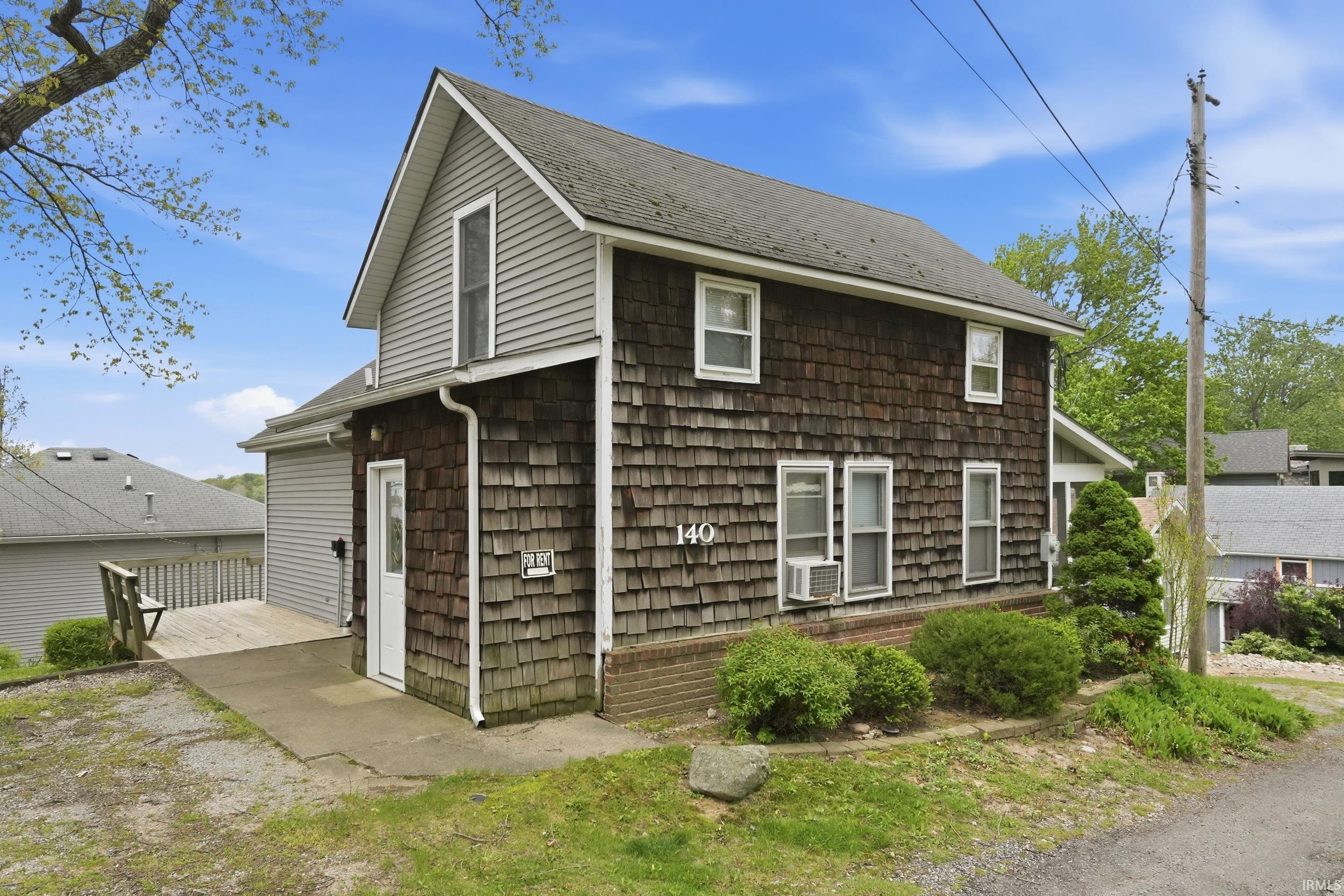 Brown shake siding exterior with white trim windows and a light gray gable