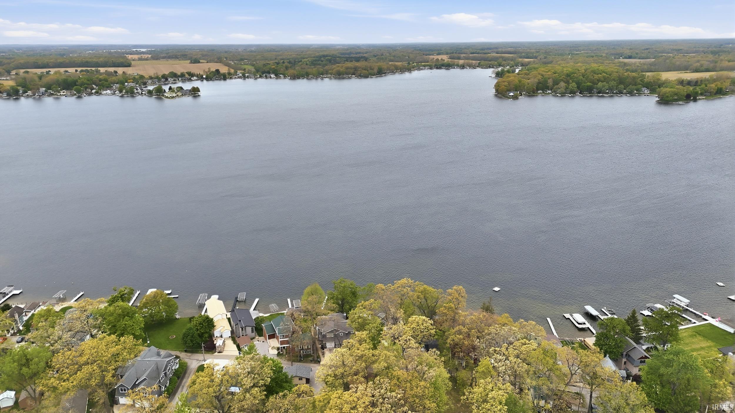 Expansive lake with a tree-lined shoreline and residential properties