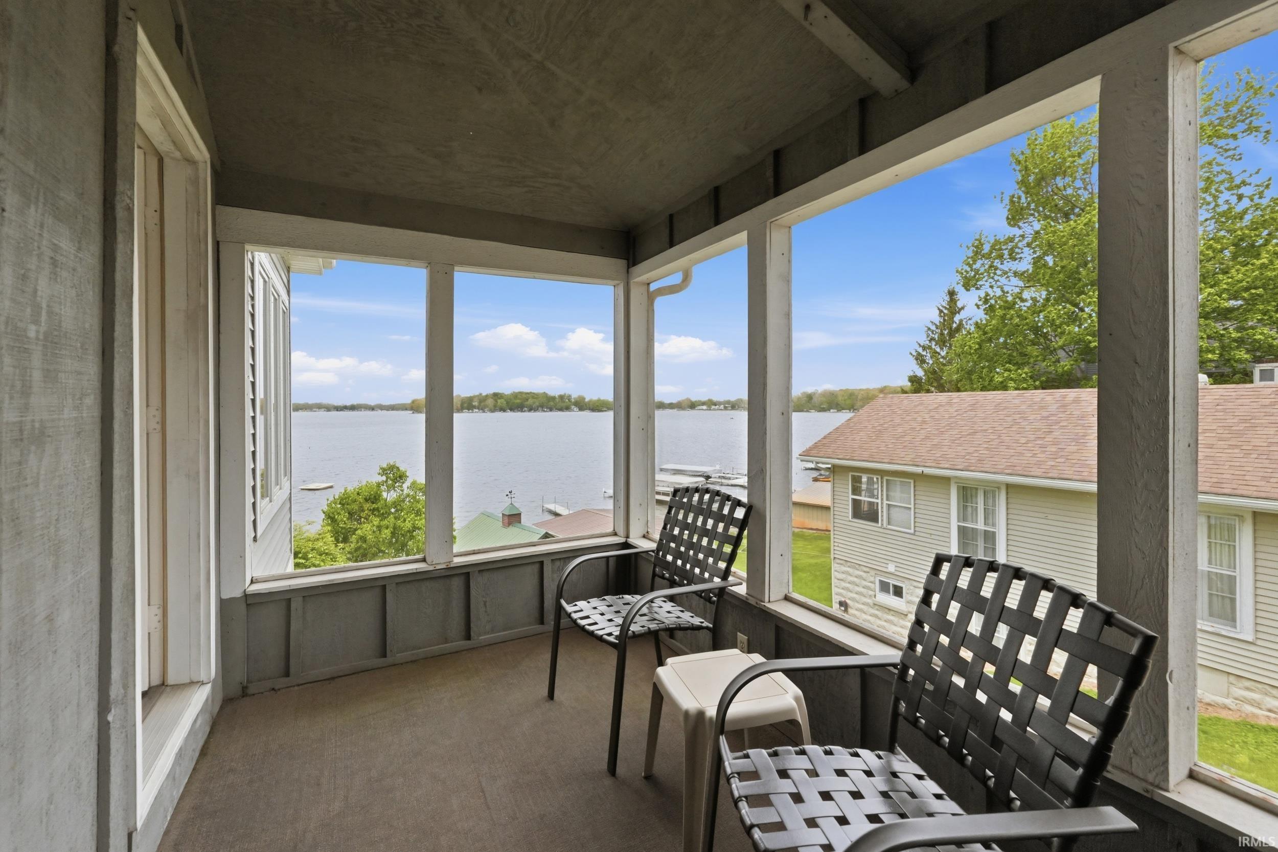 Enclosed porch with expansive water frontage and distant tree-lined shores