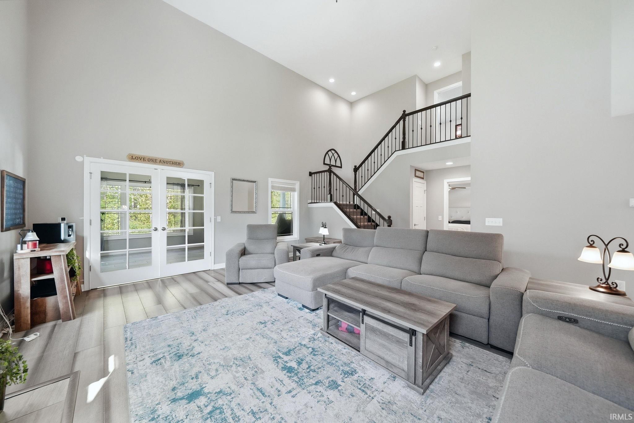 Spacious living area featuring a vaulted ceiling and light wood-finish flooring