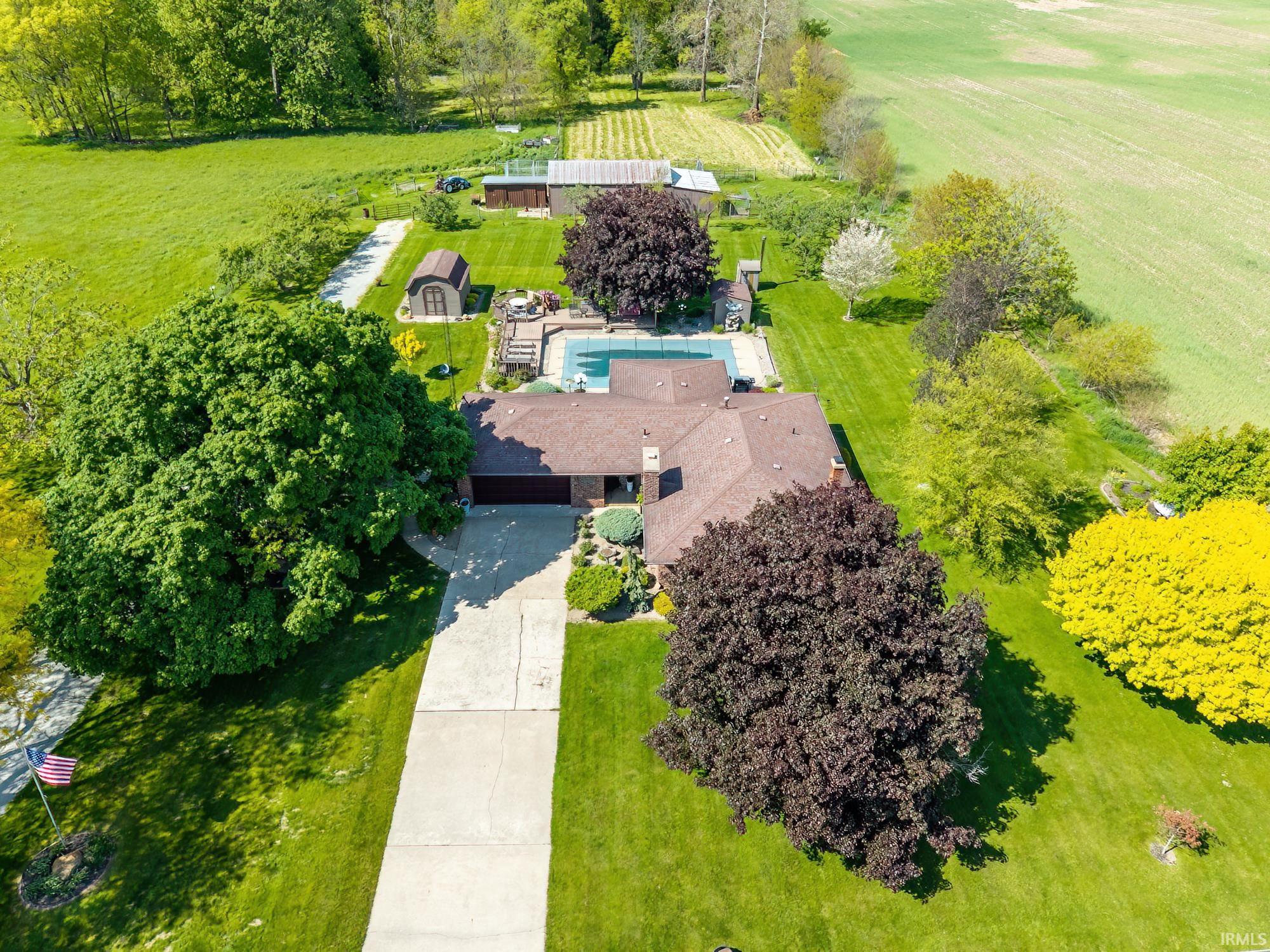 Aerial perspective showcasing a single-story residence with an attached garage, featuring a brown shingle roof