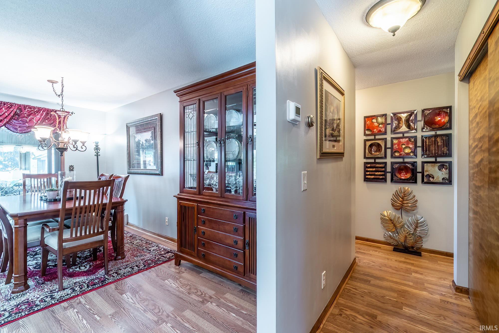 Dining area with wood-finish flooring and a decorative chandelier