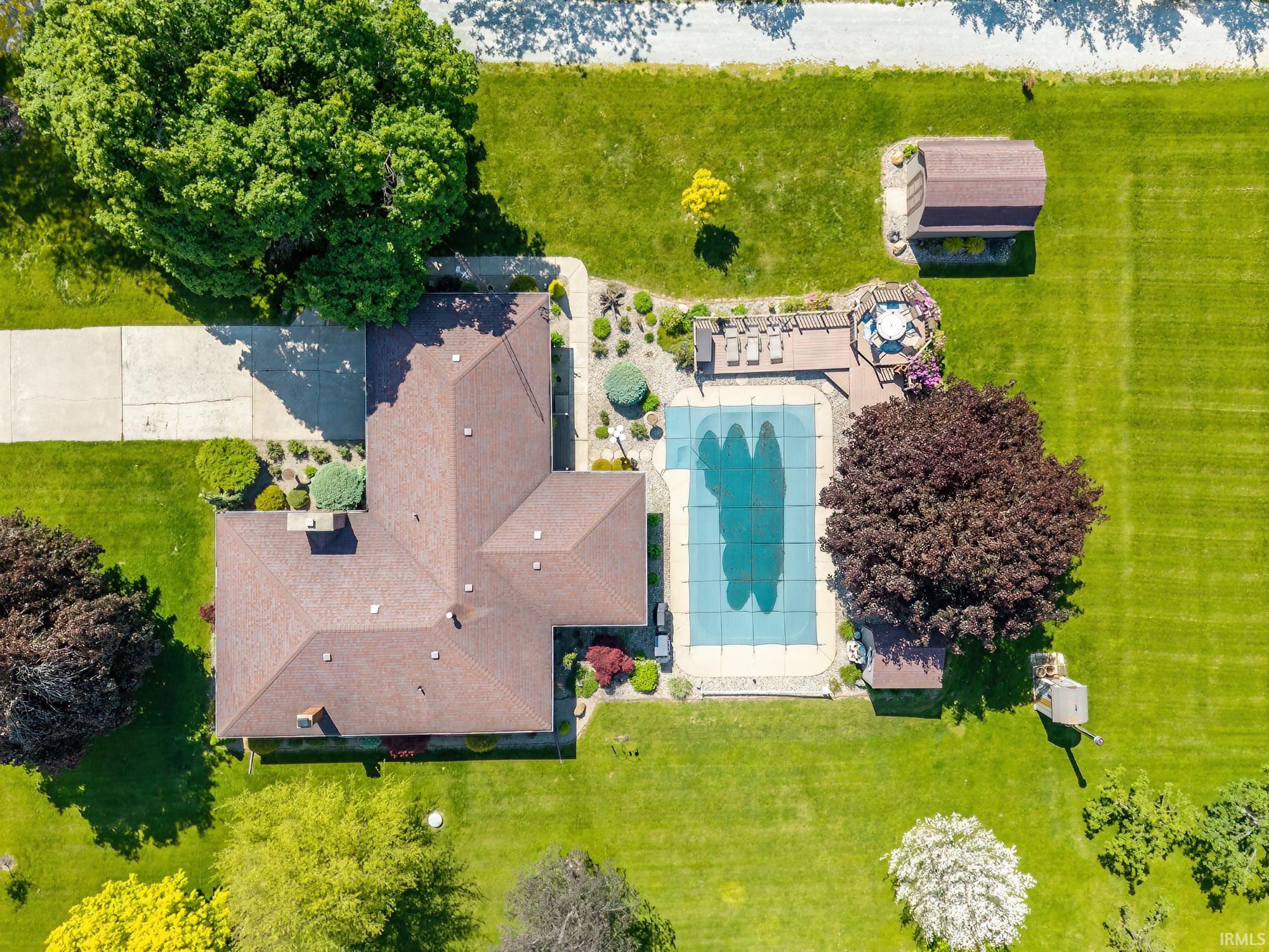 Expansive property featuring a covered in-ground swimming pool, a multi-level deck, and a detached storage shed