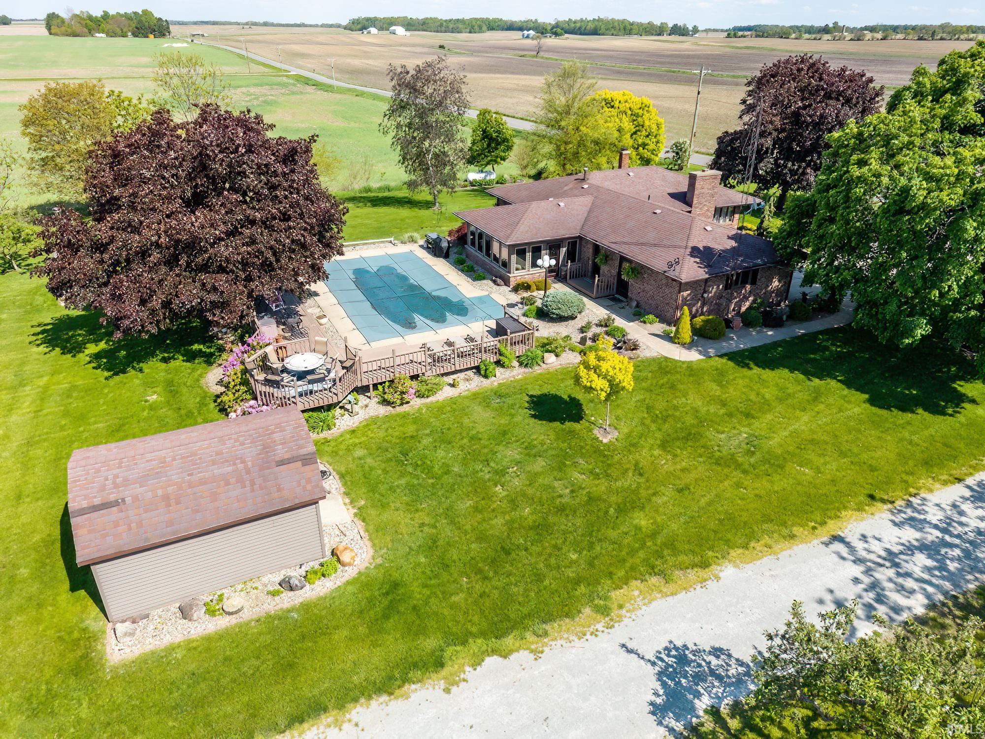 Expansive outdoor space featuring a covered swimming pool, surrounding wood deck, and a detached storage shed