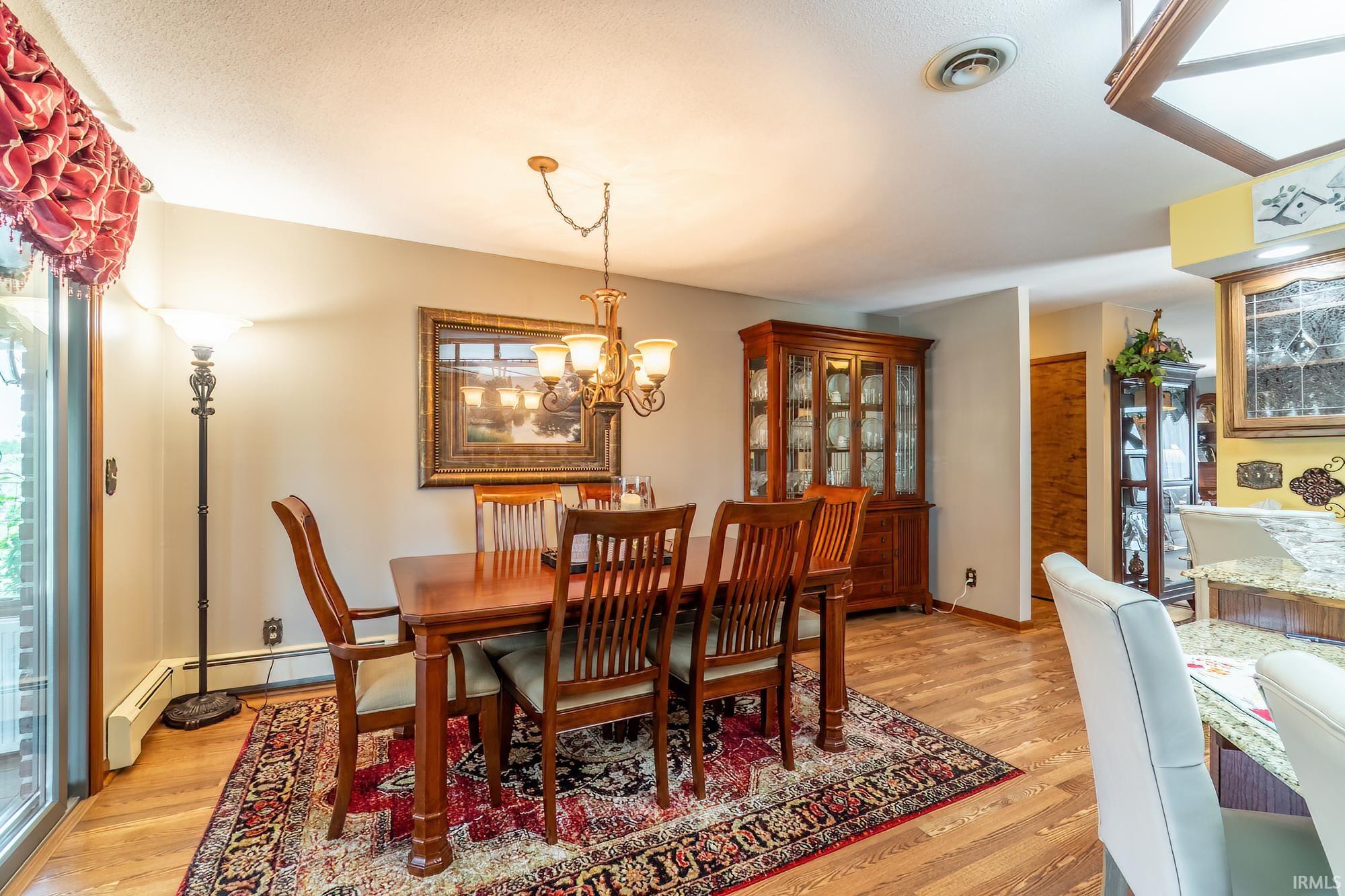 Dining area featuring wood-finish flooring and a brass chandelier