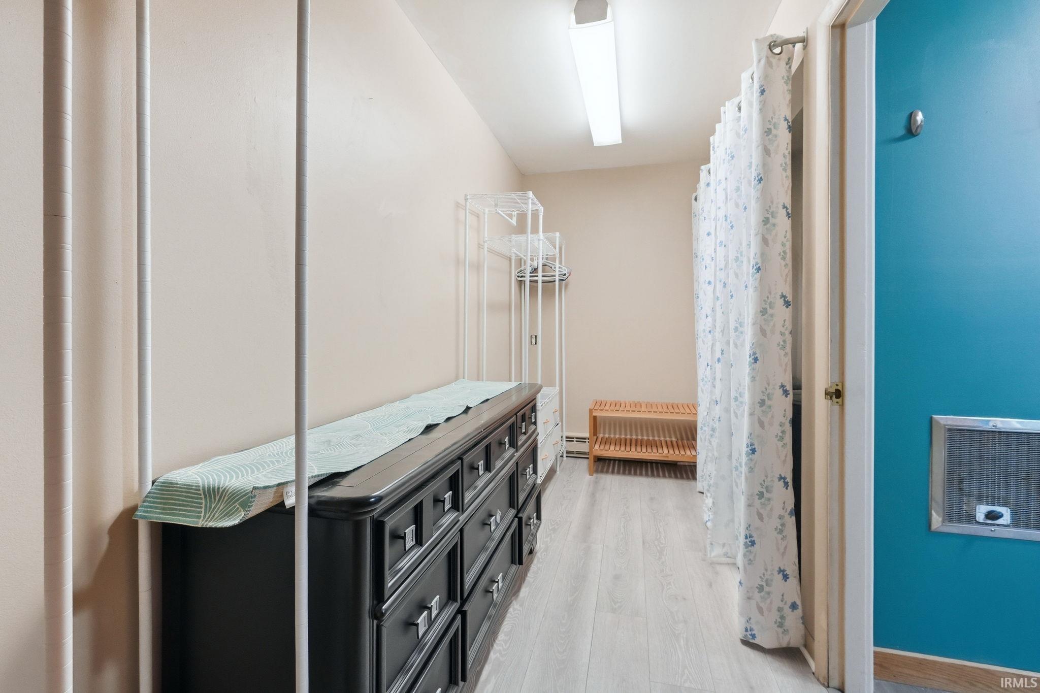 Hallway featuring light wood-finish flooring, neutral-toned walls, and a recessed ceiling light