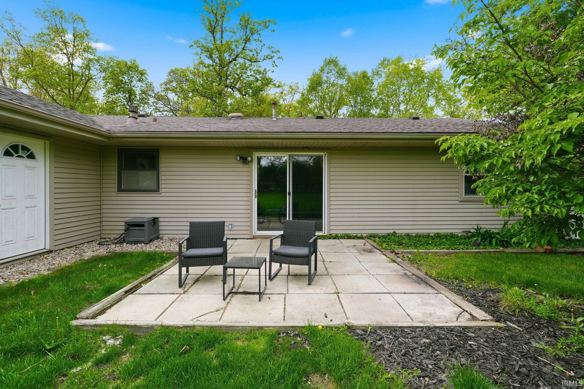 Rear patio space featuring a sliding glass door and durable siding
