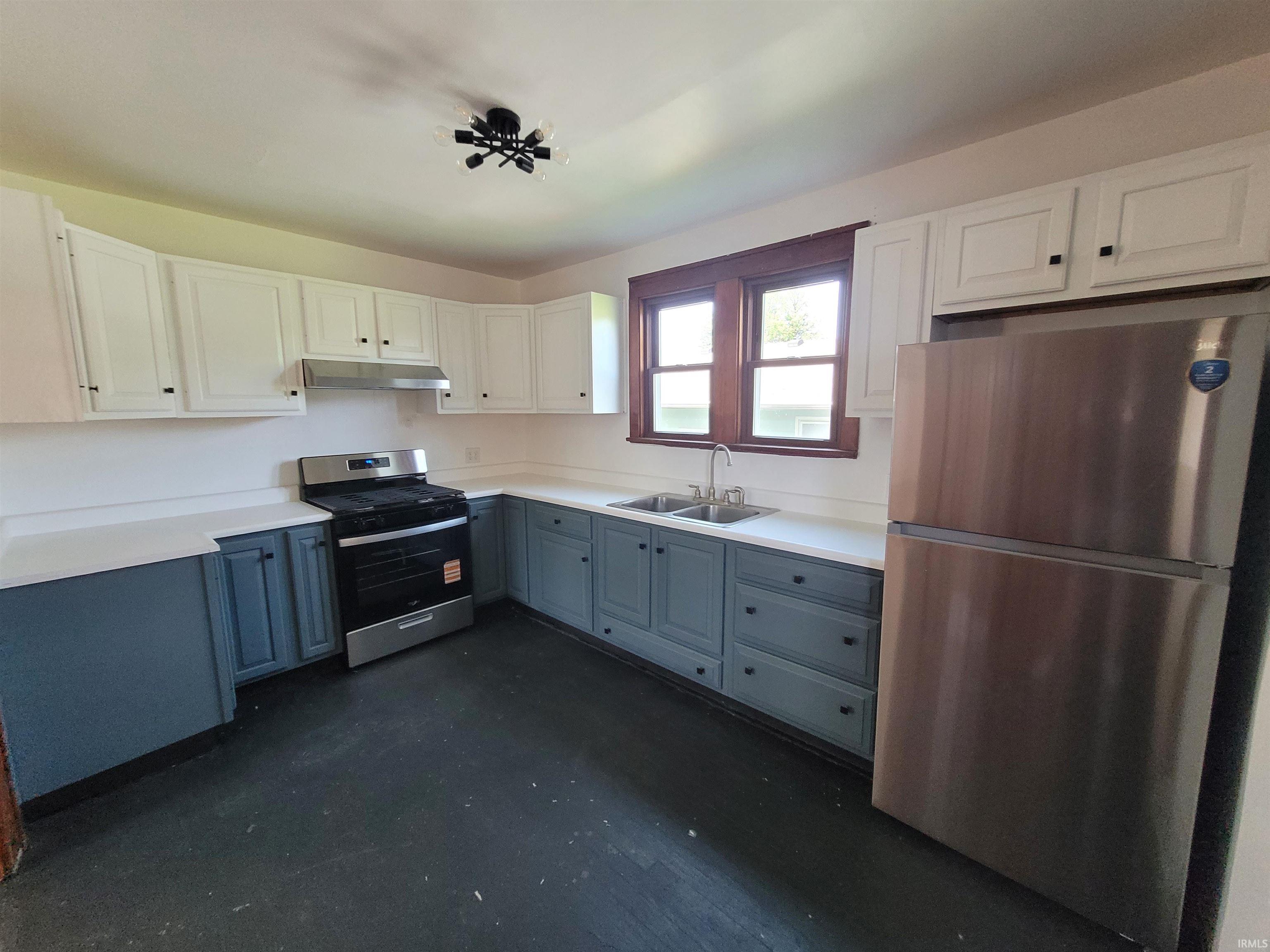 Kitchen featuring two-tone cabinetry, white countertops, and wood-finish flooring