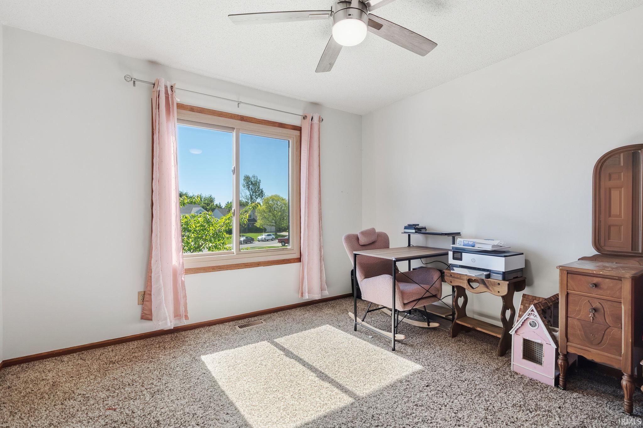 Room featuring a double-pane window, wall-to-wall carpeting, and a ceiling fan with integrated lighting