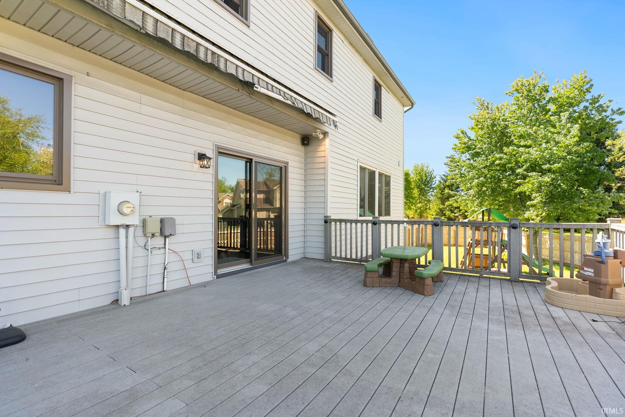 Spacious composite deck extending from the home, featuring a sliding glass door for interior access and a privacy railing
