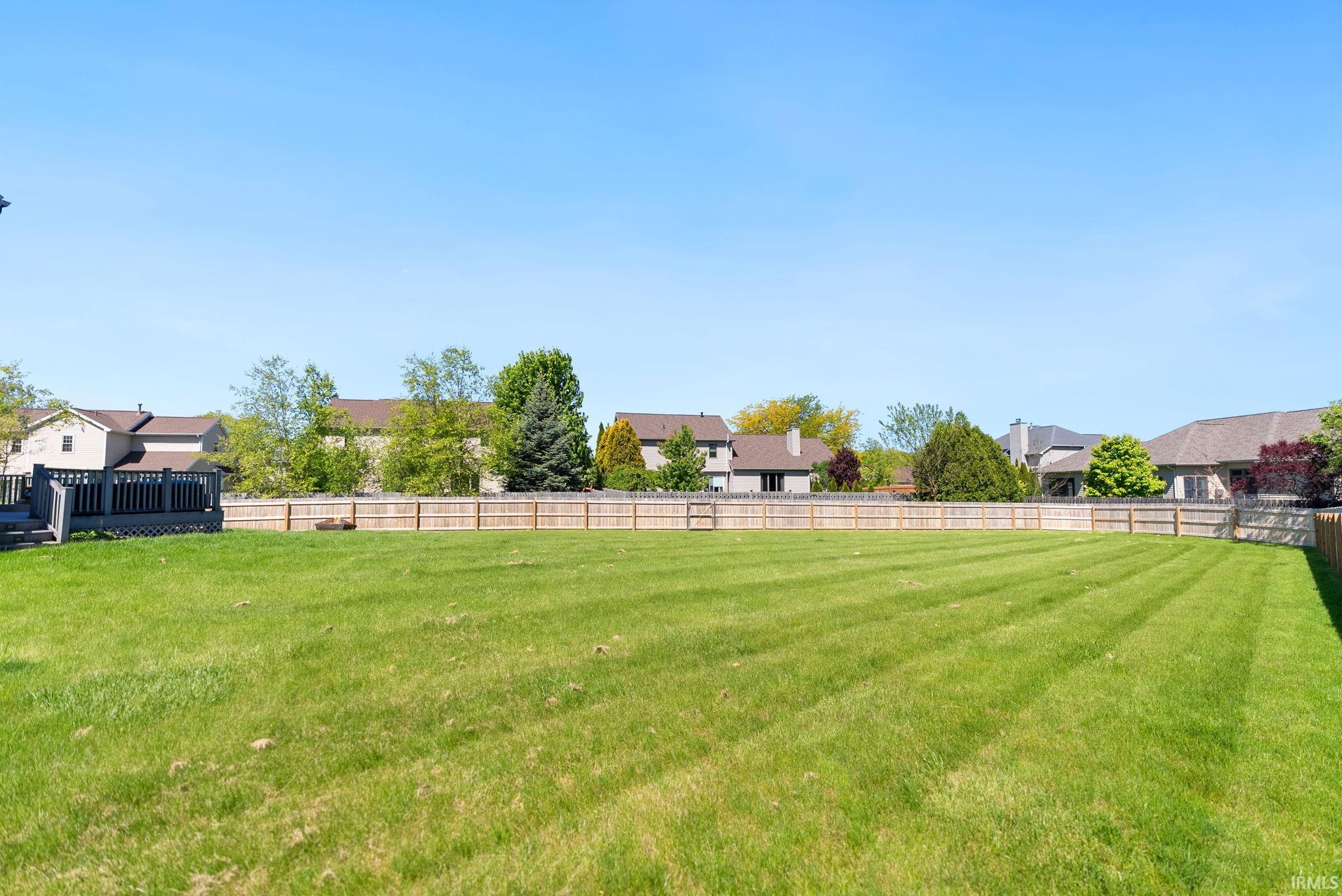 Expansive lawn with a full perimeter wood privacy fence
