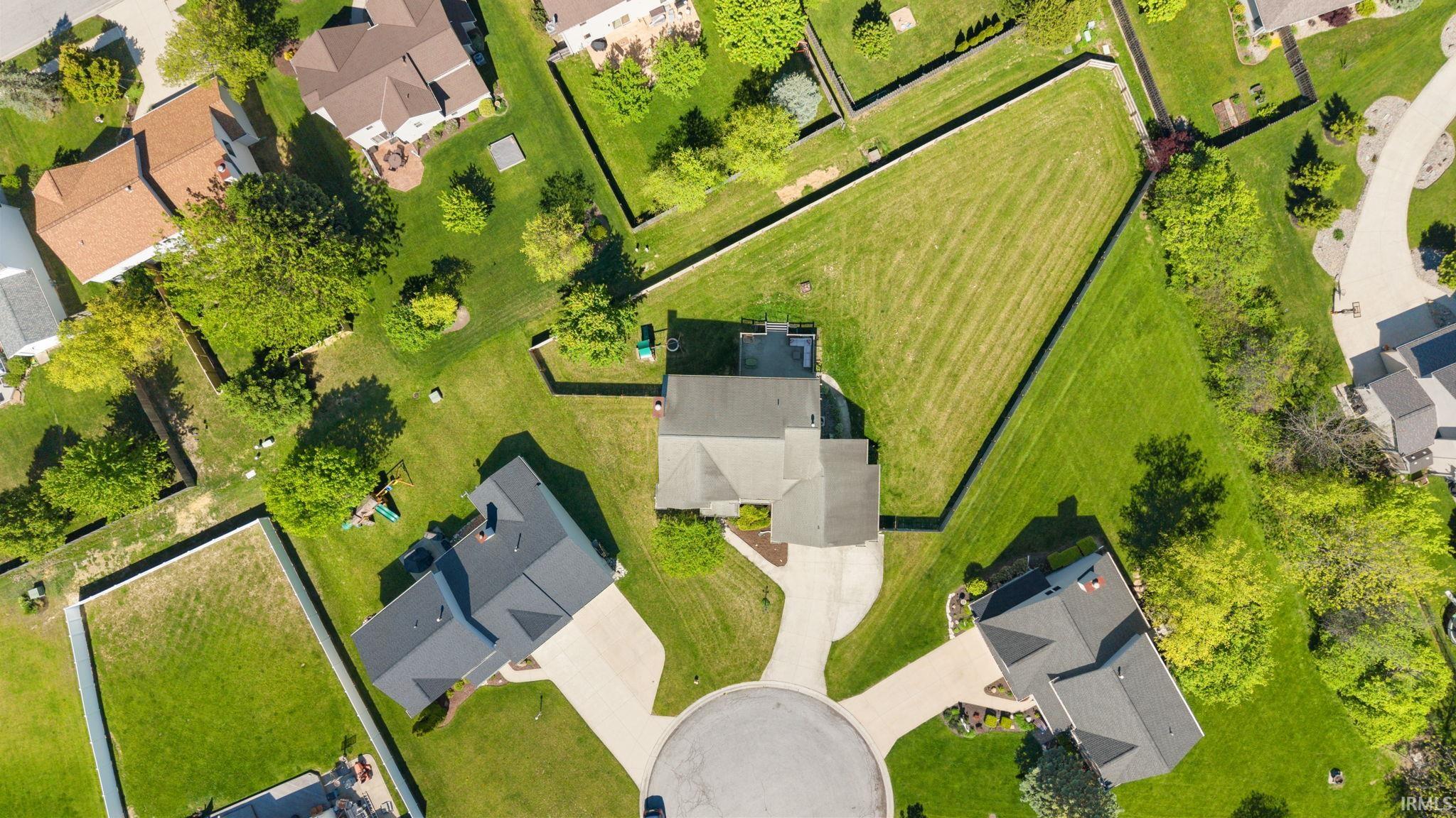 Aerial perspective showcasing a residential cul-de-sac with mature trees, green lawns, and varied rooflines