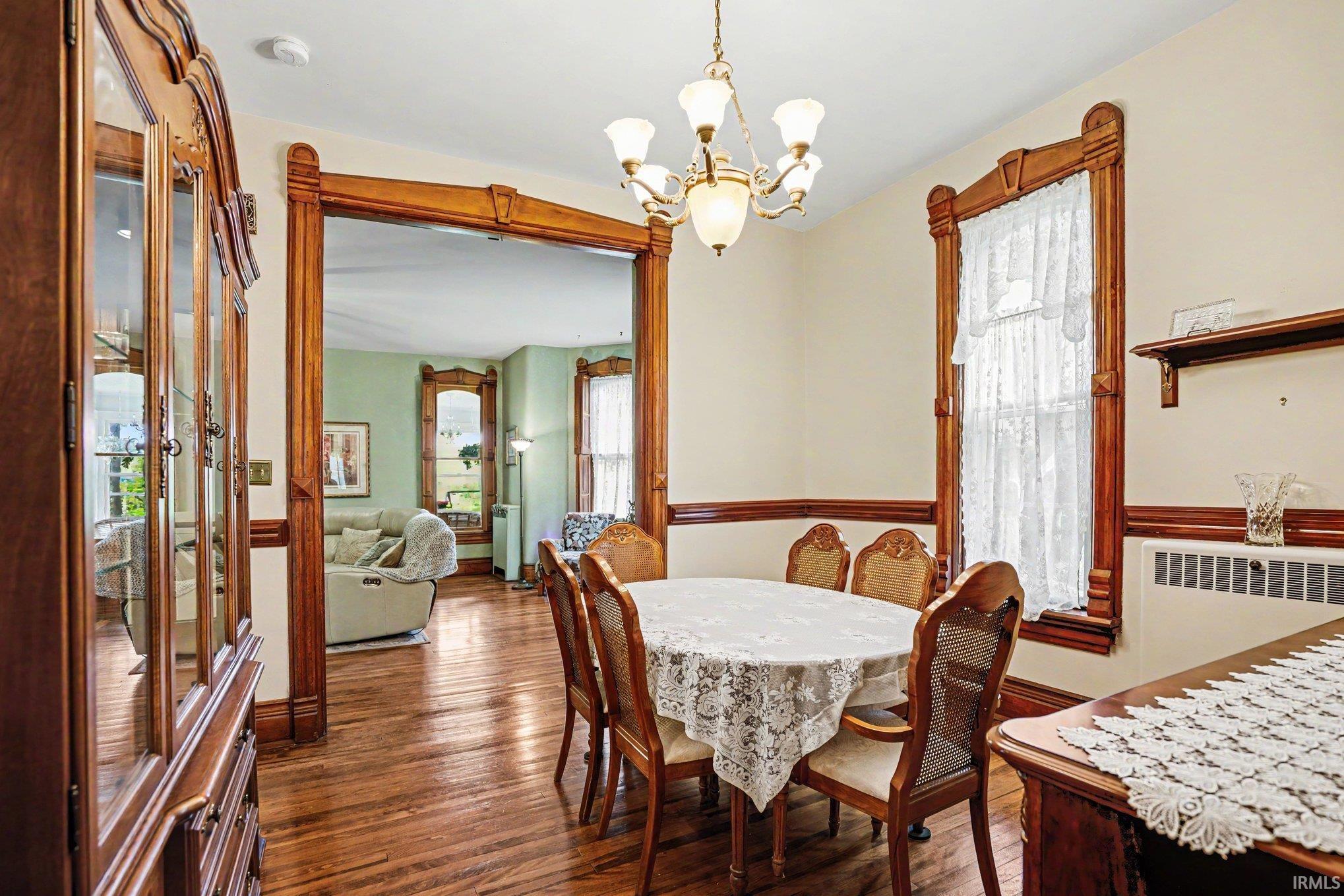 Formal dining area featuring rich wood-finish flooring and intricate wood trim