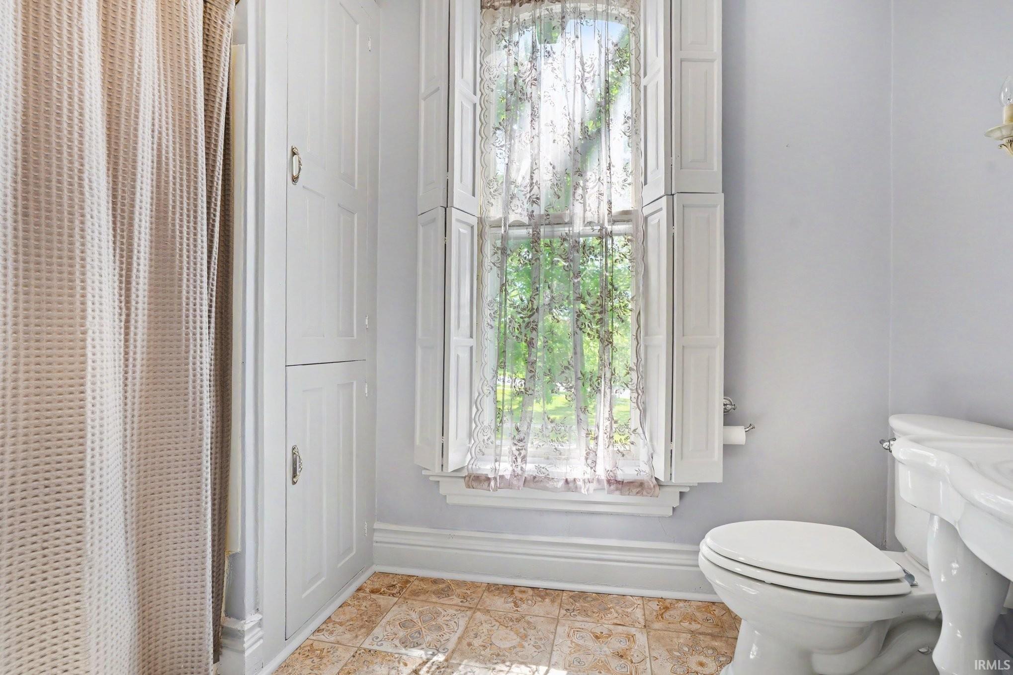 Upstairs second full bathroom Window with interior shutters and lace curtain