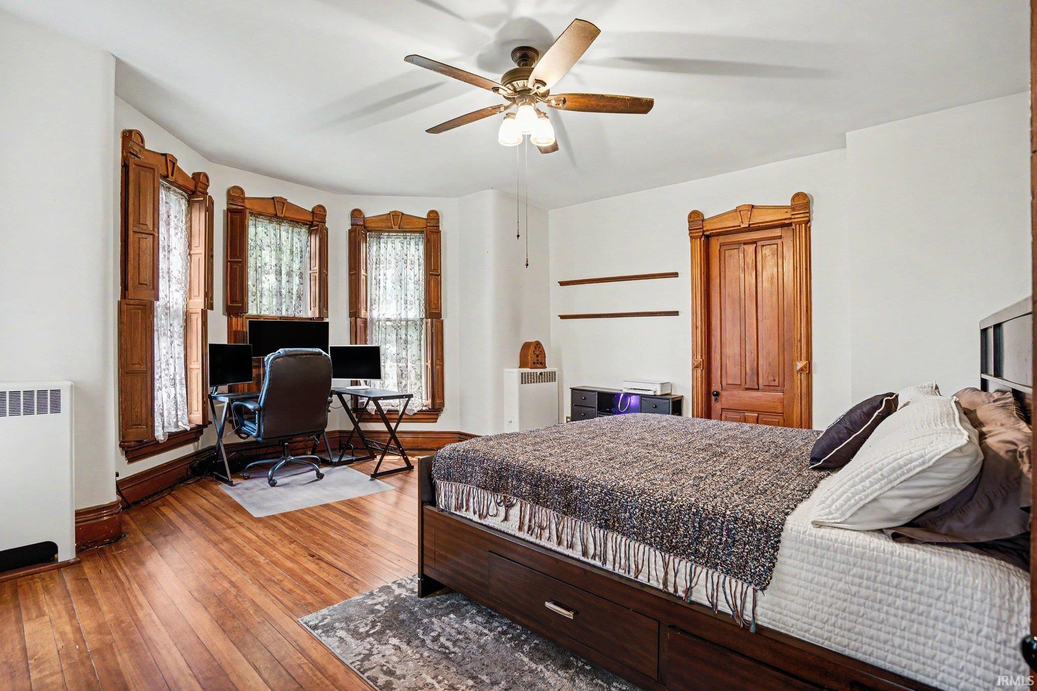 Upstairs master bedroom with closet...room featuring hardwood flooring and a ceiling fan