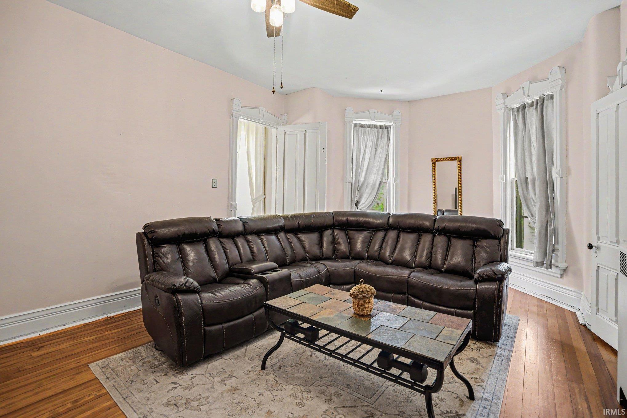 Upstairs bedroom currently being used as a living space...Hardwood flooring complemented by white baseboards and crown molding and a closet