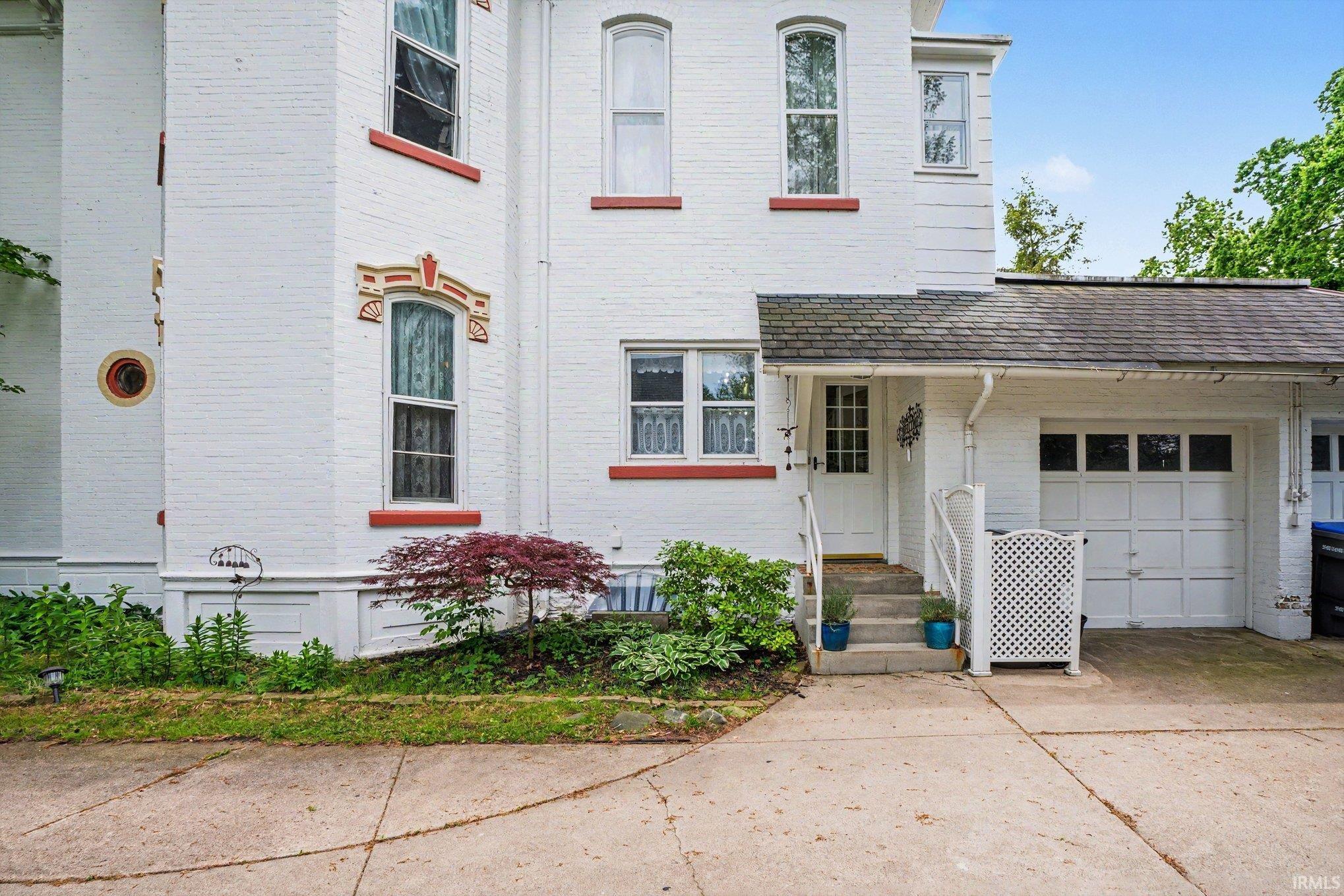 White brick exterior featuring arched windows with decorative sills