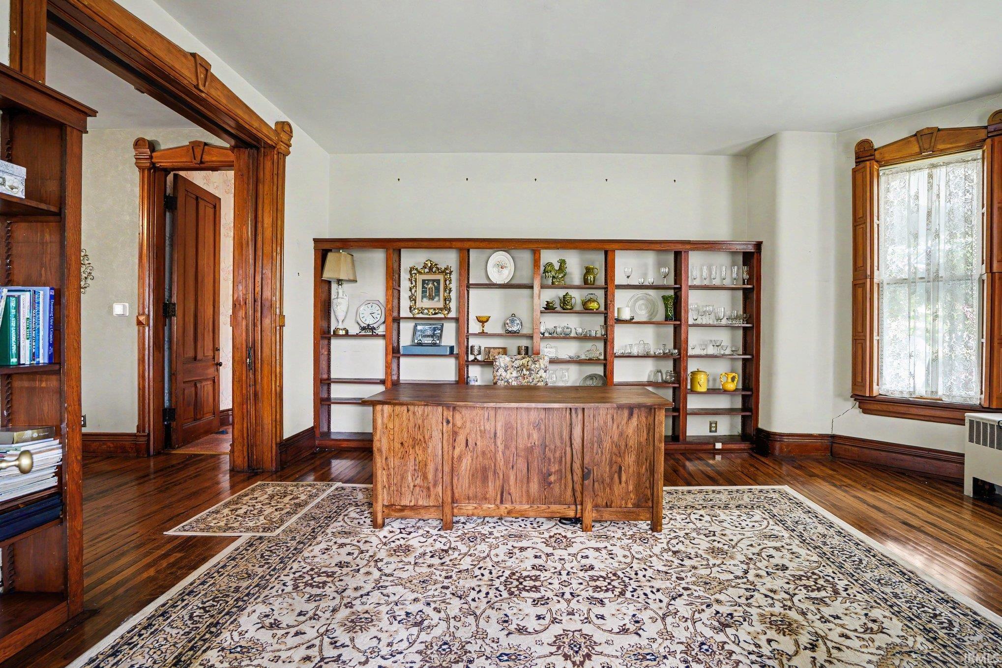 Wood-finish flooring throughout, featuring a broad area rug