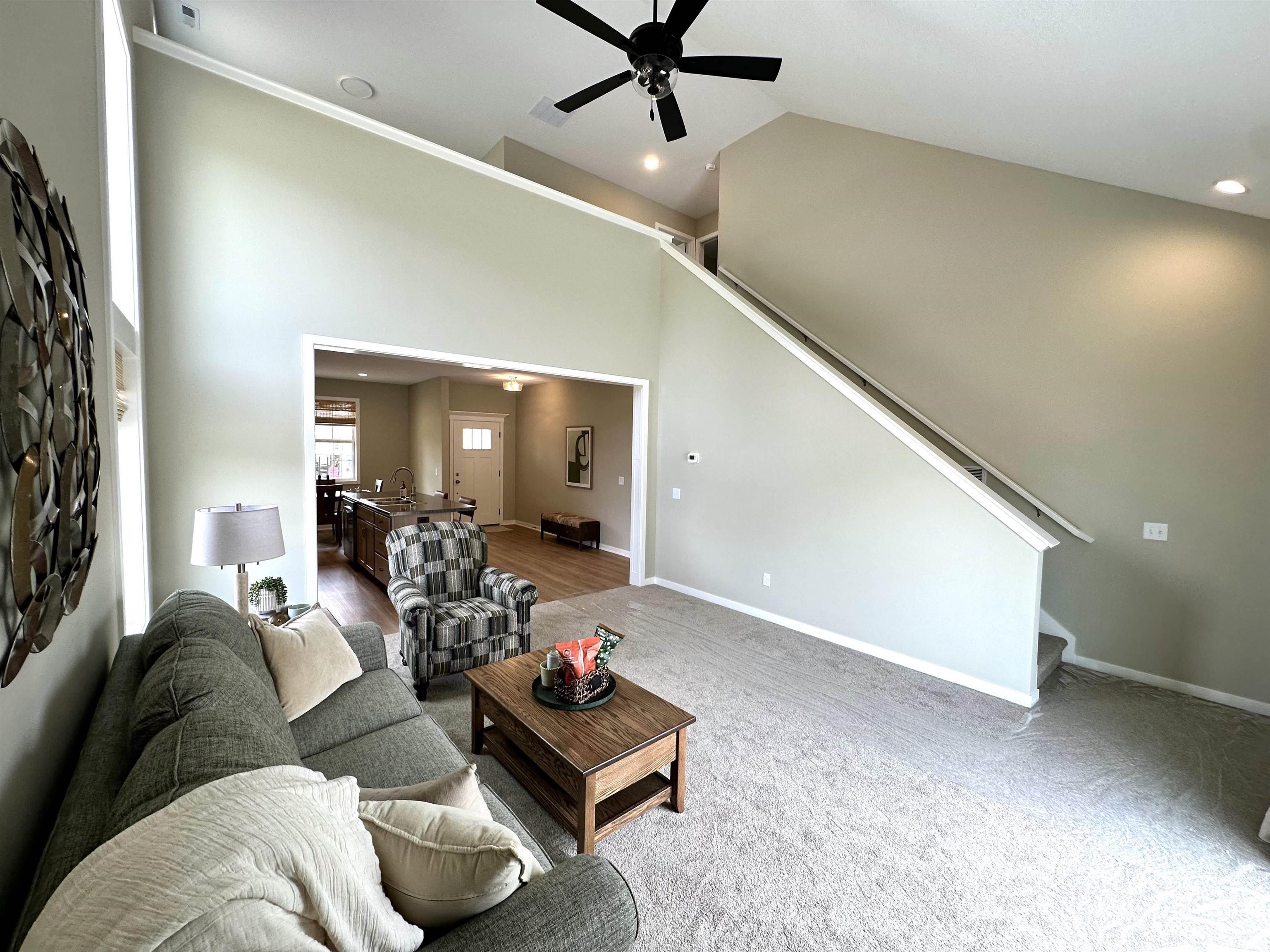 Great room featuring vaulted ceilings, recessed lighting, a ceiling fan, and carpet flooring