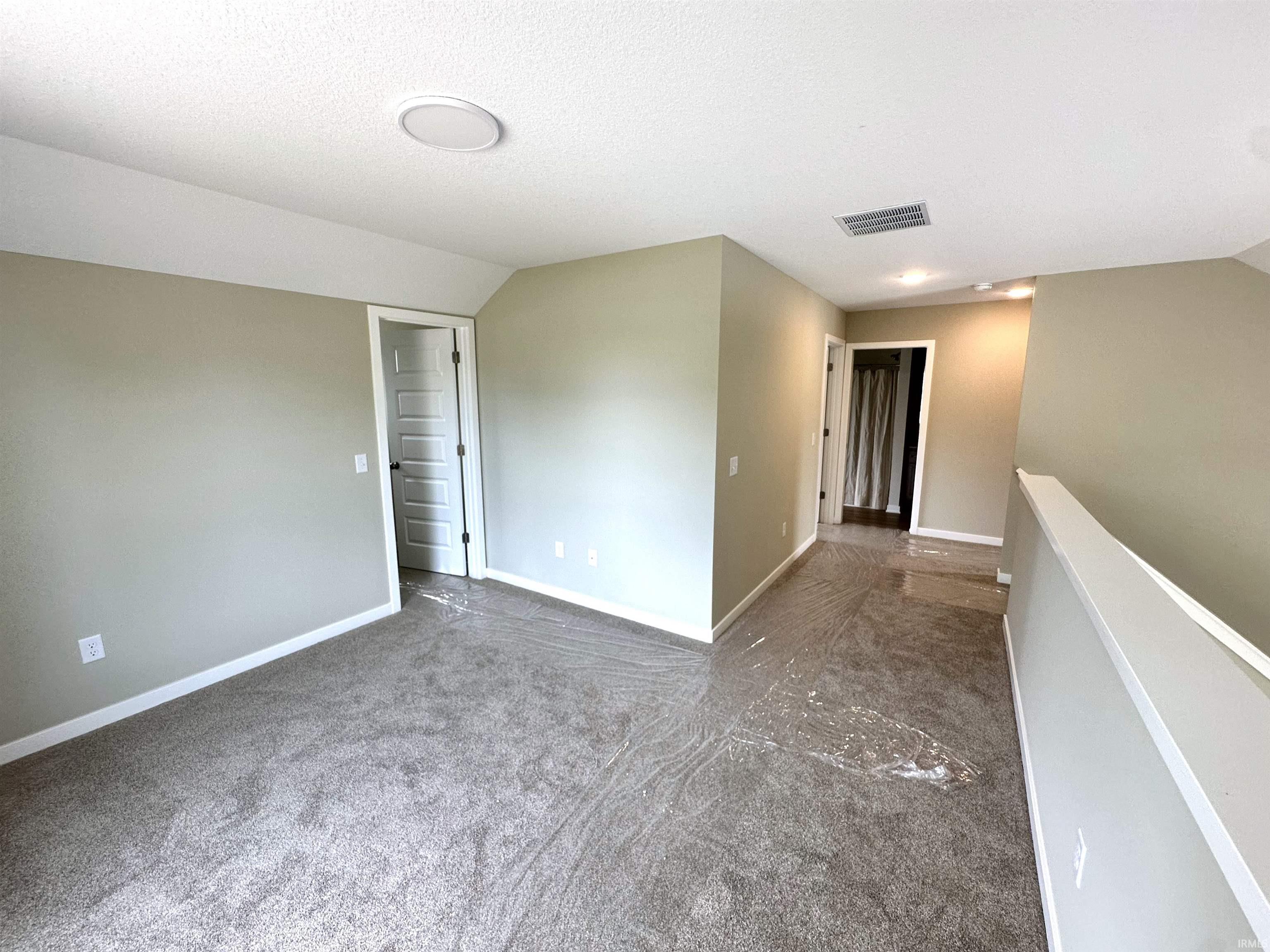 Carpeted interior space with neutral wall paint and white trim
