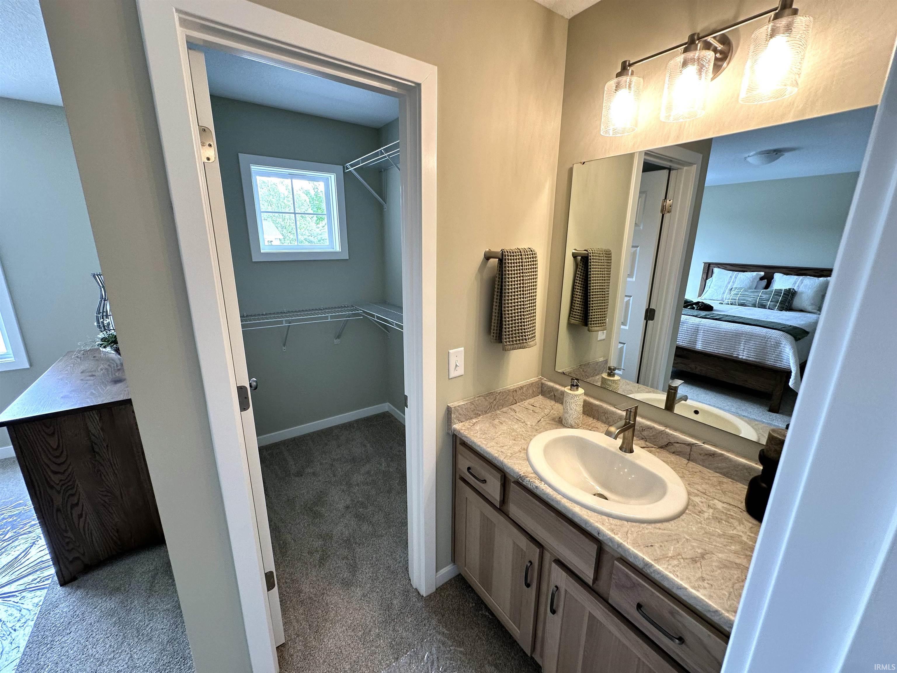 Bathroom vanity with a light-toned countertop, under-mount sink, and brushed nickel faucet