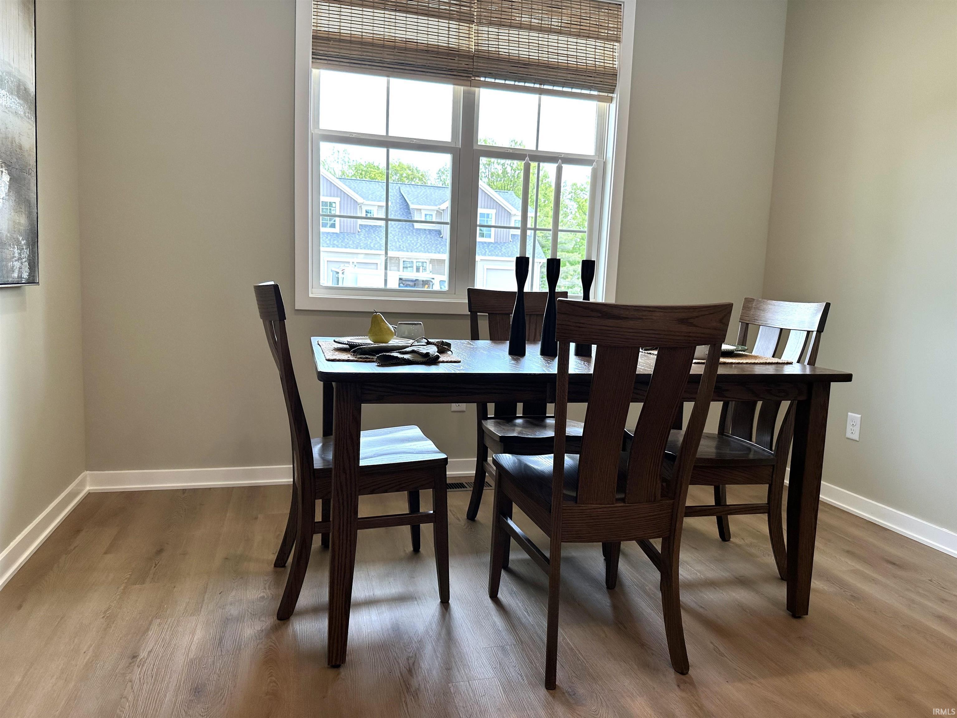 Bright interior space featuring a double-hung window with natural light, wood-finish flooring, and neutral wall tones