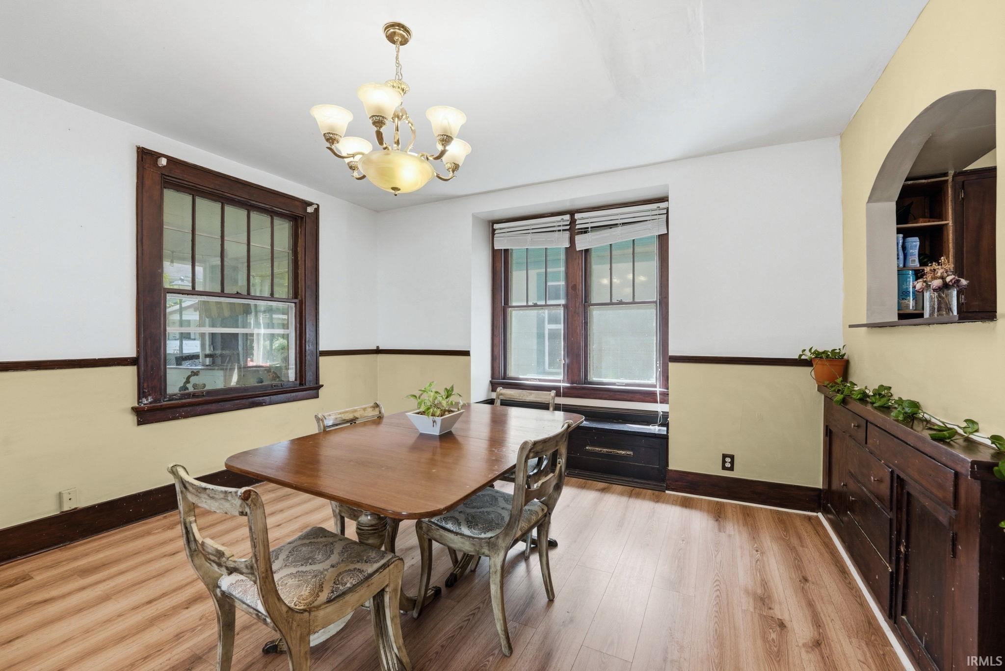 Wood-finish flooring throughout, featuring a traditional chandelier
