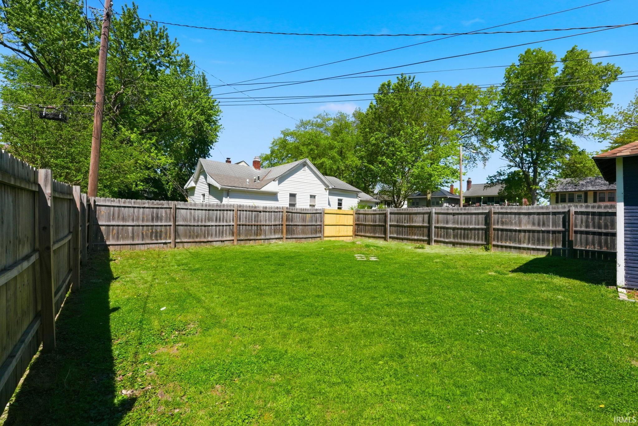 Expansive green lawn surrounded by wood privacy fencing