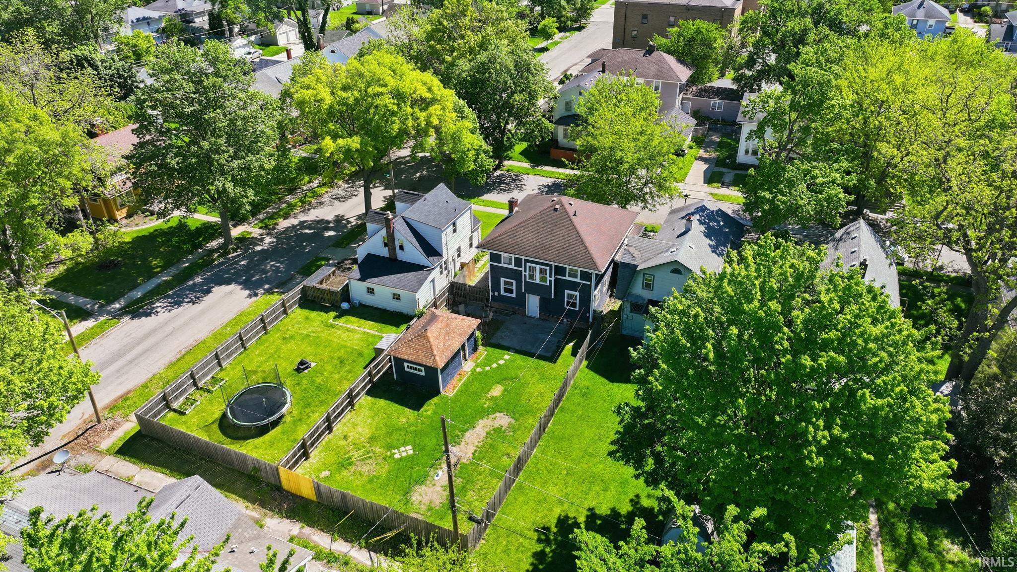 Expansive lot featuring a fenced yard, detached accessory building, and mature trees