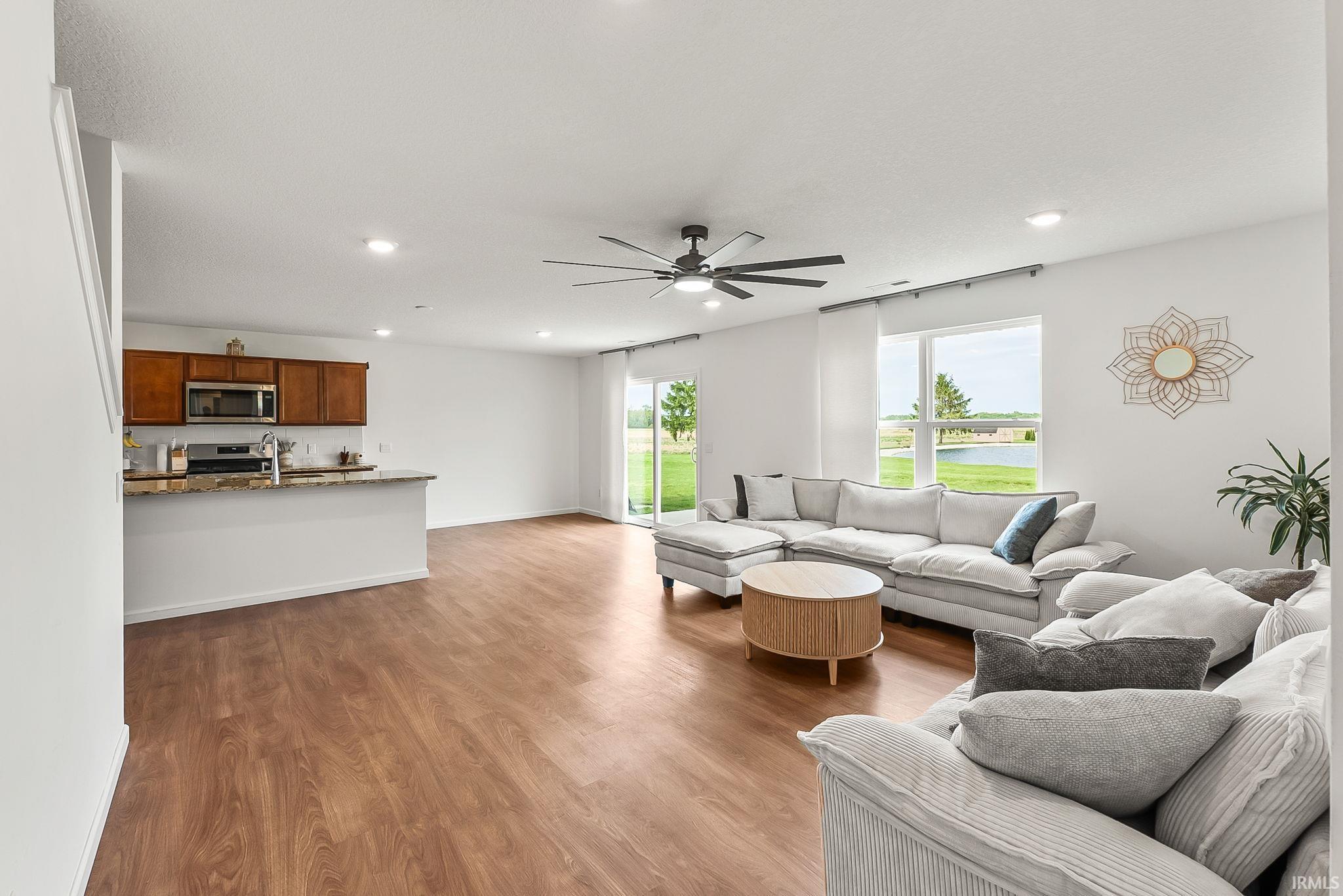 Open-concept living area featuring wood-finish flooring, recessed lighting, and a ceiling fan
