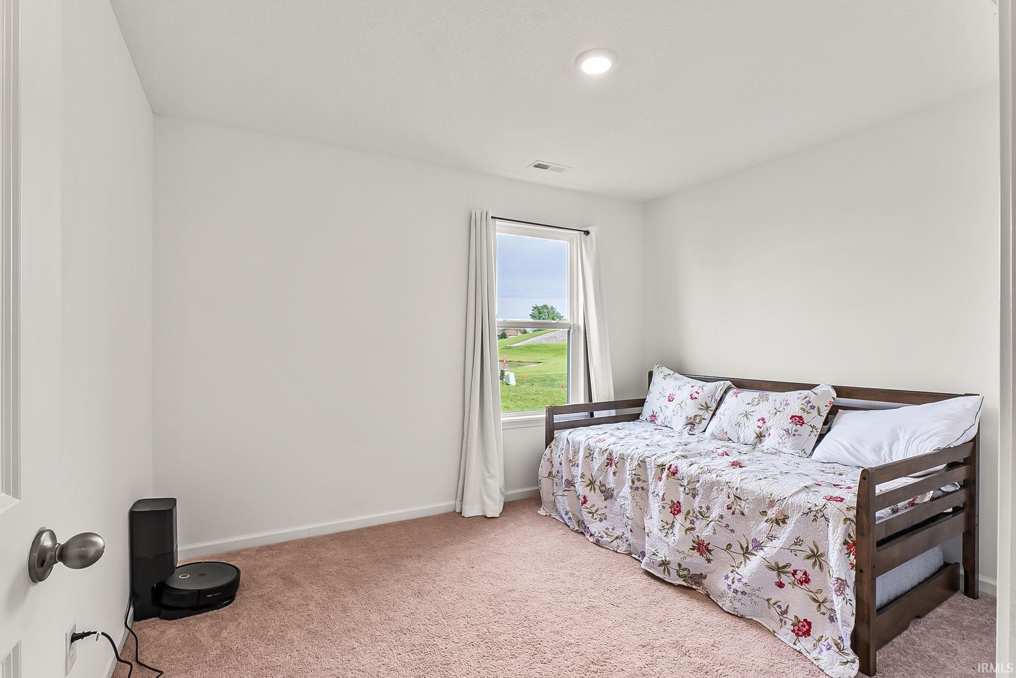 Room featuring light-colored walls, recessed ceiling lighting, and soft pink carpeting