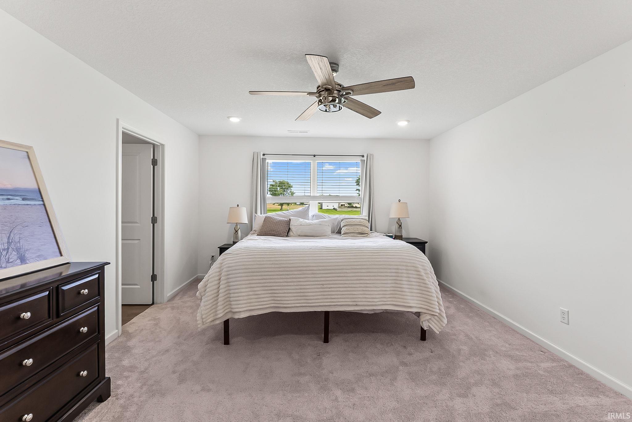 Carpeted room featuring a ceiling fan with light fixture, recessed lighting, and a window with horizontal blinds