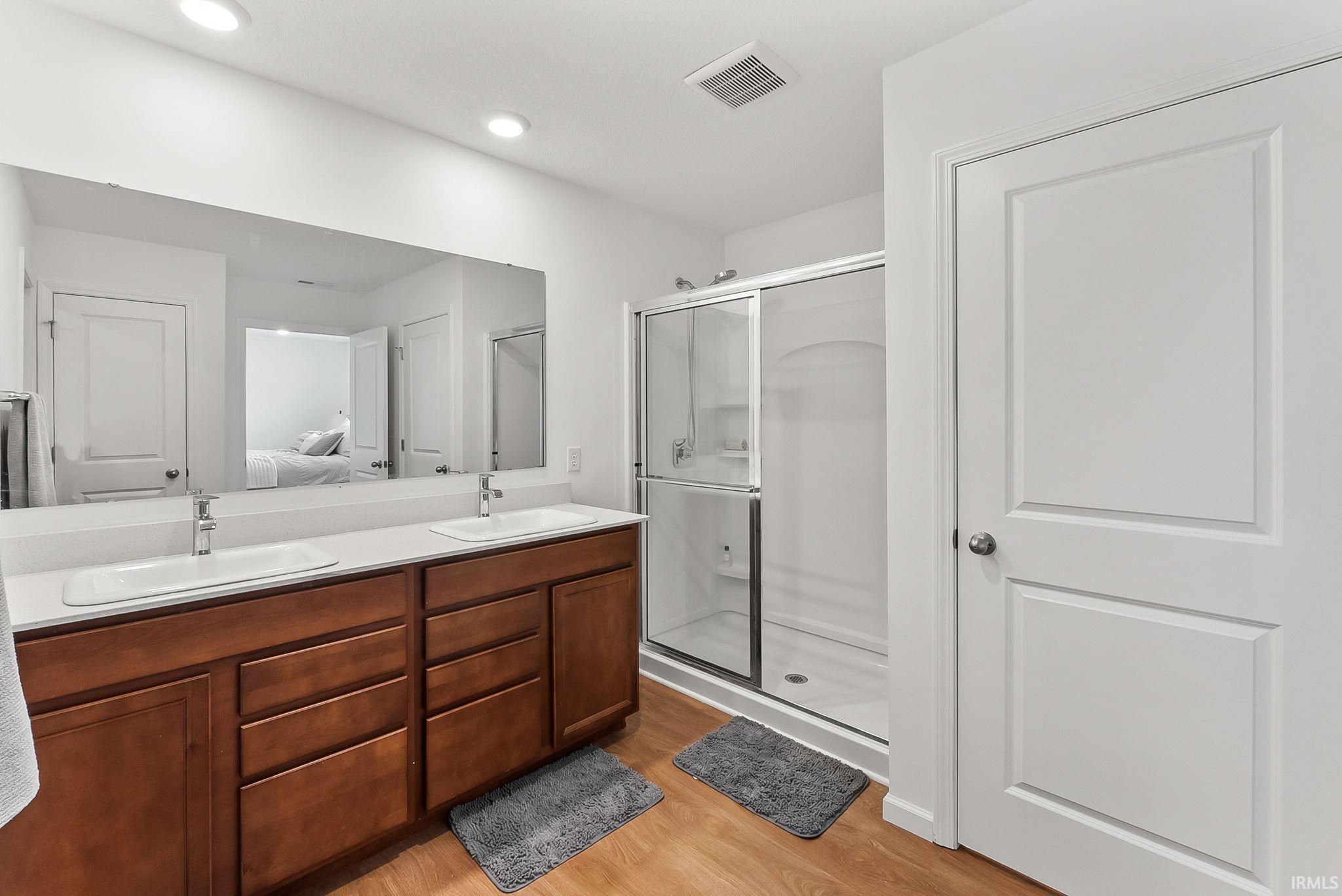 Bathroom featuring a dual vanity with a light-colored countertop and dark wood-finish cabinetry