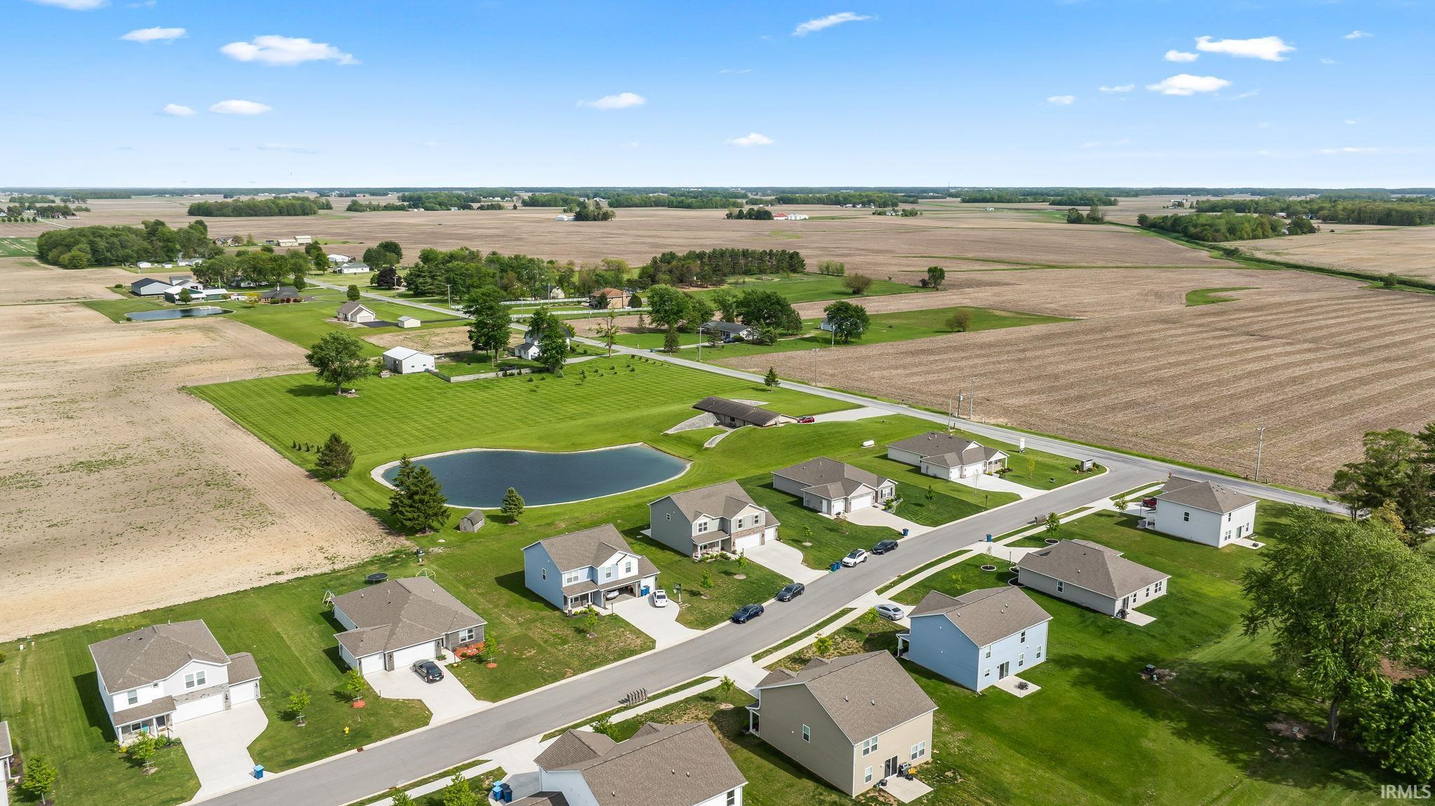 Expansive aerial landscape highlighting a developed residential subdivision and surrounding agricultural fields