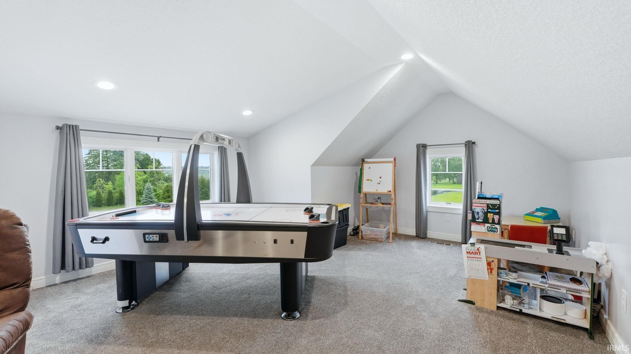Spacious bonus room featuring vaulted ceilings, recessed lighting, and multiple windows