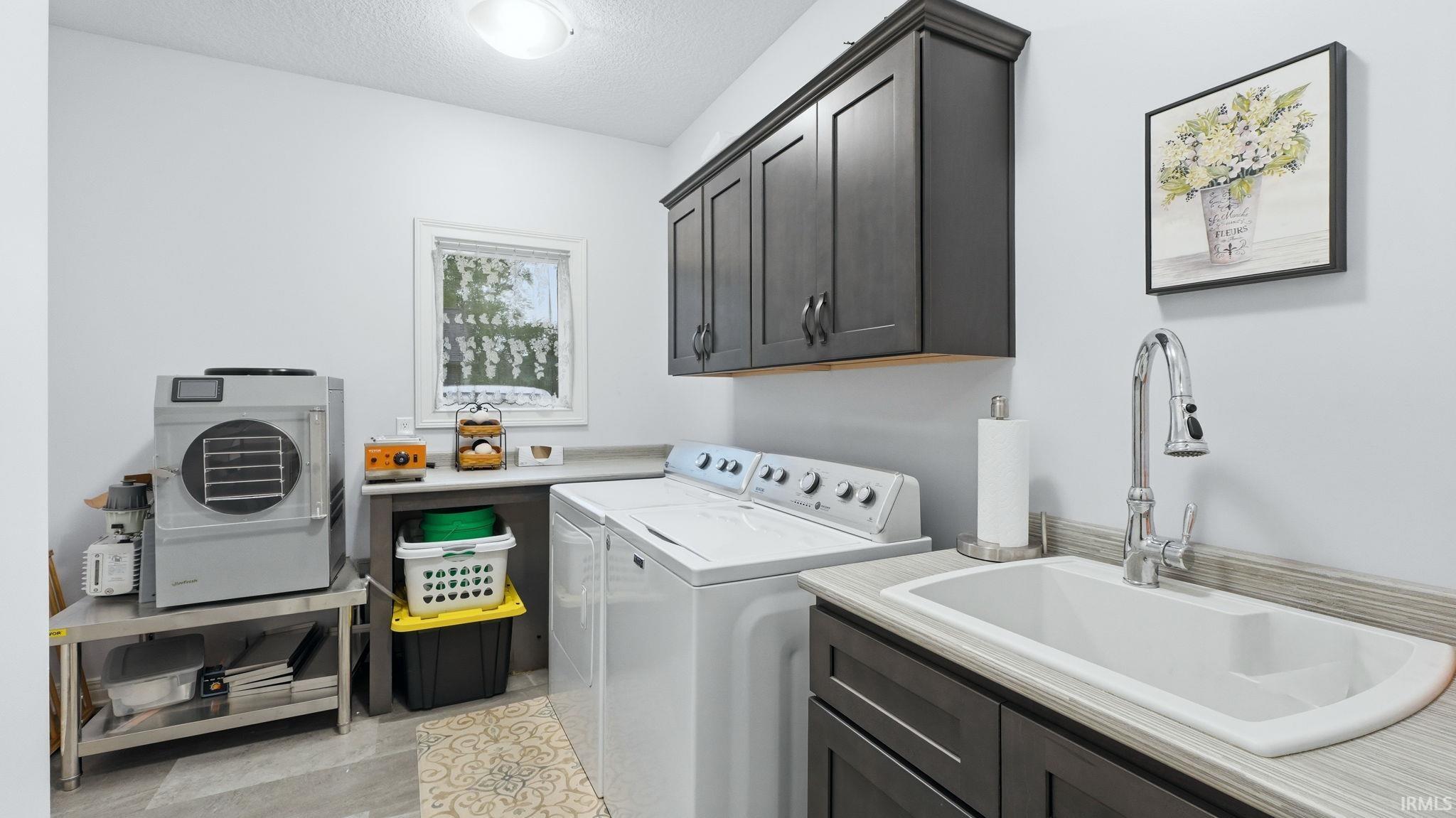 Utility room featuring a built-in sink with a chrome gooseneck faucet, dark wood-finish cabinetry, and a window for natural light