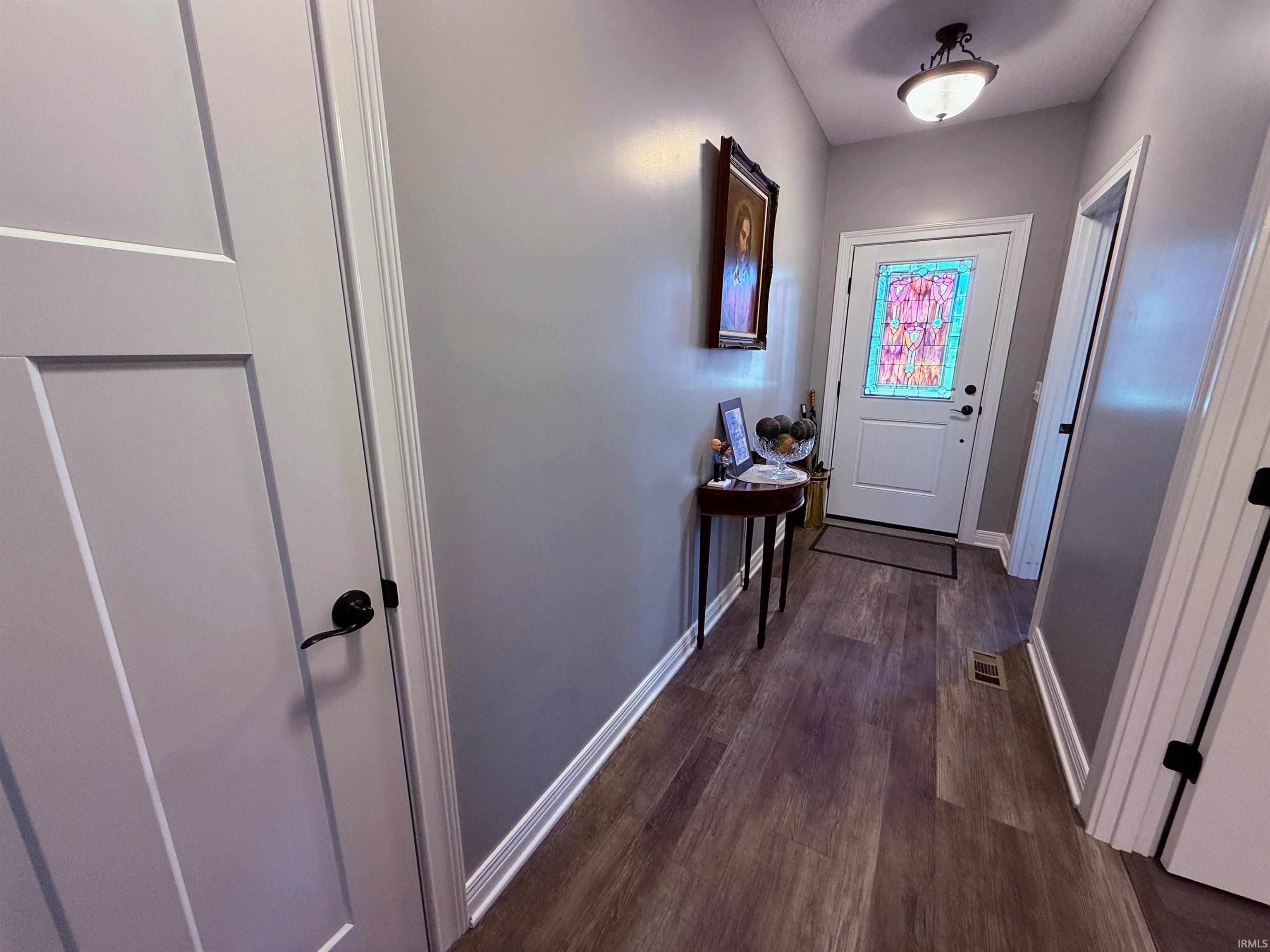 Entryway featuring a white front door with decorative glass inlay